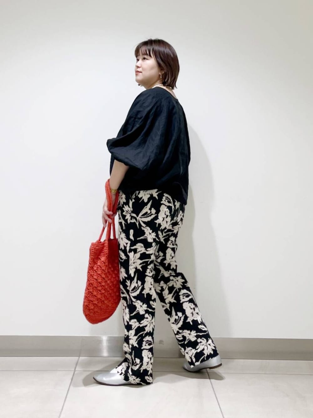 シルバー系のパンプス、ブラック系のその他パンツ、オレンジ系のトートバッグを着用したレディースの春コーディネートの5枚目の写真