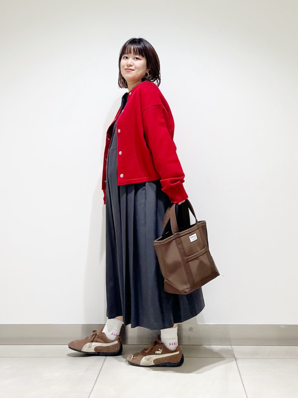 グレー系のワンピース、ブラウン系のトートバッグ、レッド系のカーディガン/ボレロを着用したレディースの秋コーディネートの8枚目の写真