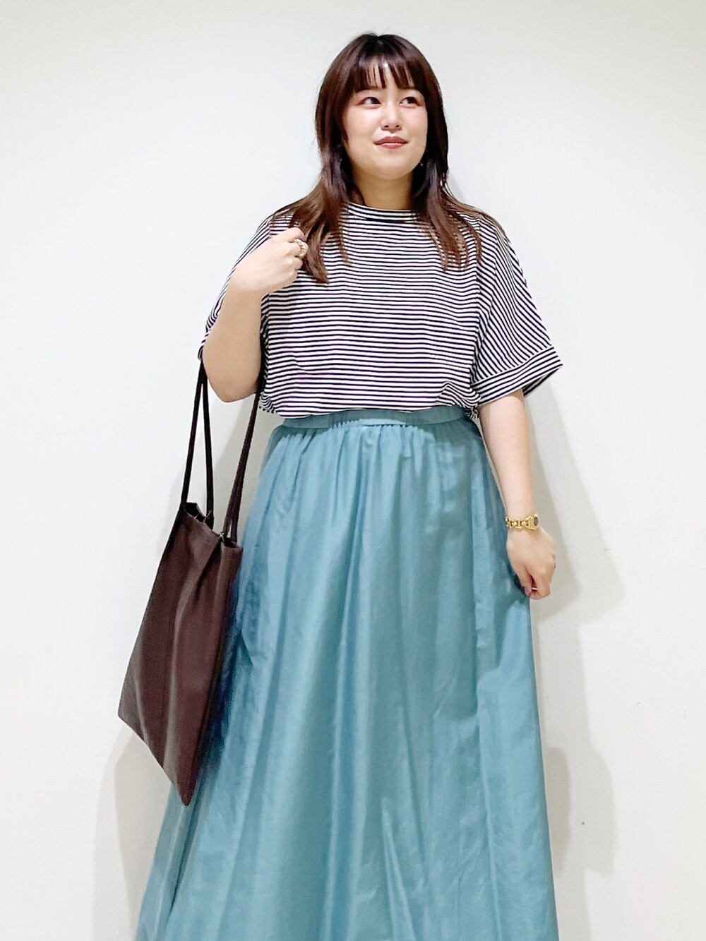 ホワイト系のTシャツ/カットソー、ホワイト系のスカート、ブラウン系のトートバッグを着用したレディースの夏コーディネートの4枚目の写真