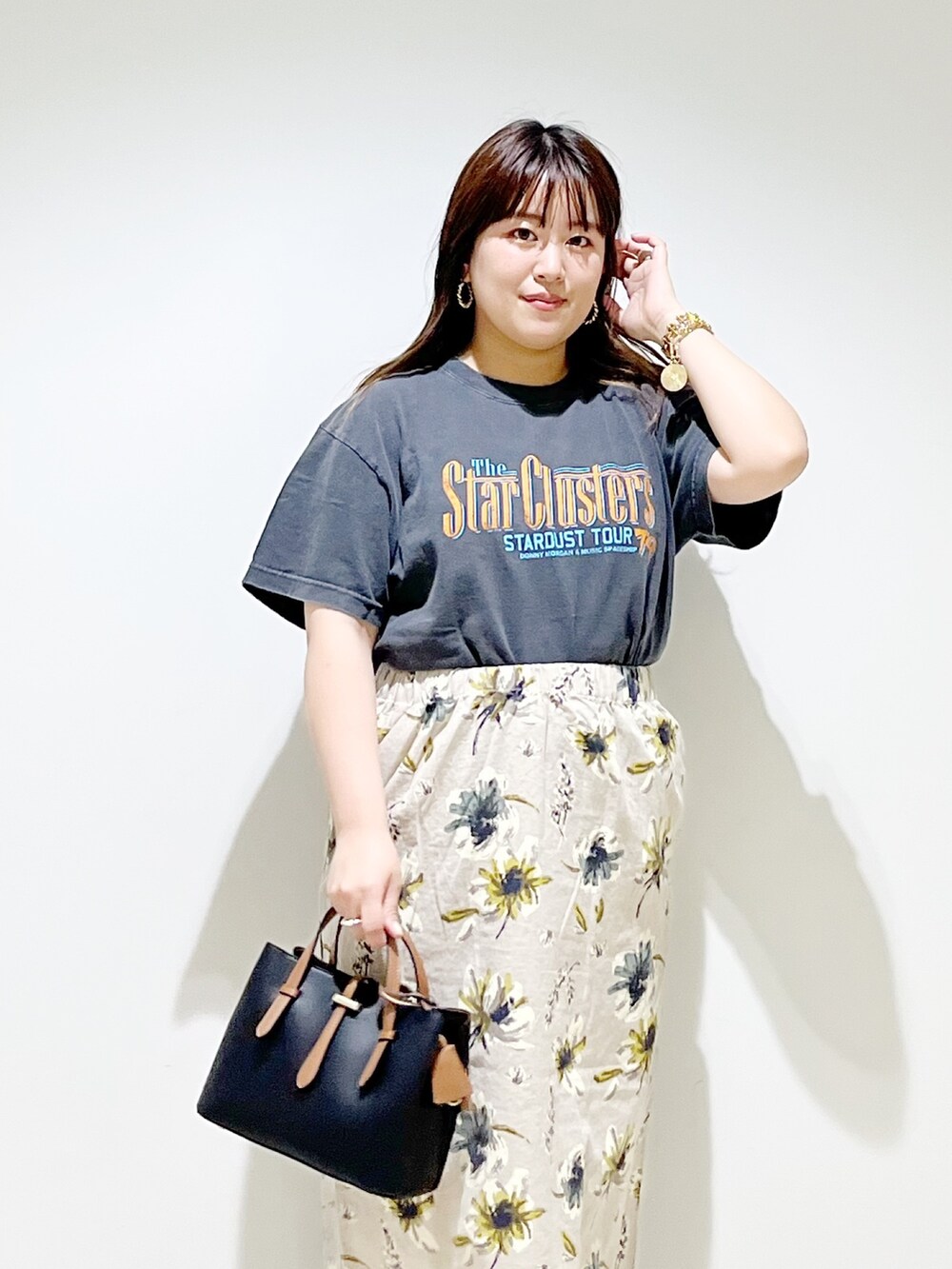 オレンジ系のTシャツ/カットソー、ブラック系のハンドバッグ、イエロー系のスカートを着用したレディースの夏コーディネートの9枚目の写真