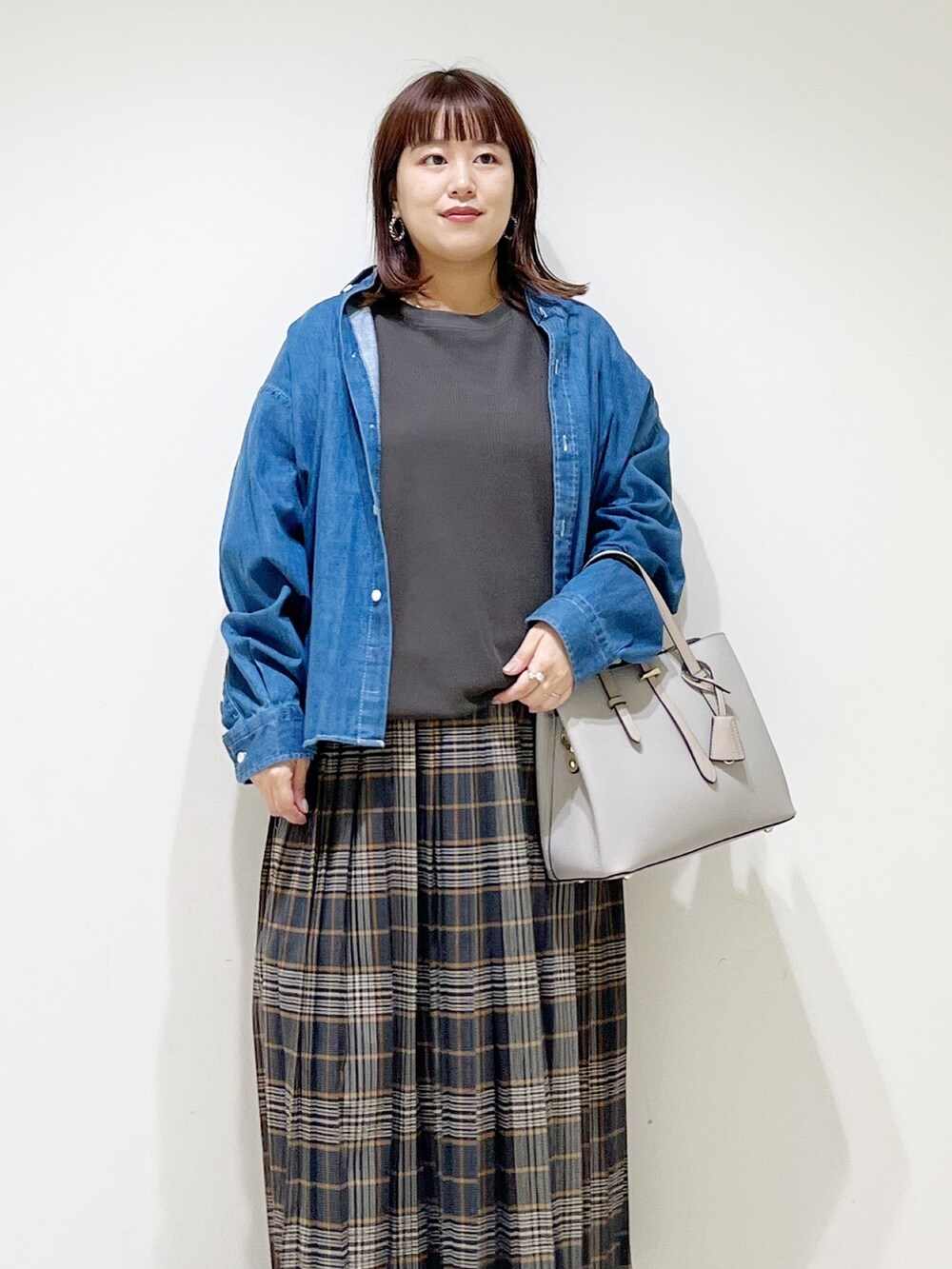 グレー系のTシャツ/カットソー、グレー系のトートバッグ、グレー系のスカートを着用したレディースの秋コーディネートの8枚目の写真