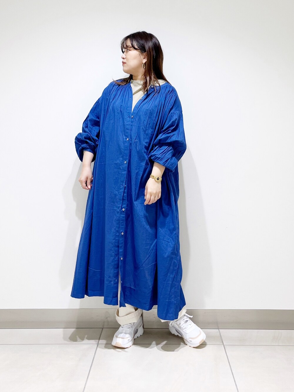 ブルー系のワンピース、ベージュ系のデニムパンツ、ベージュ系のTシャツ/カットソーを着用したレディースの春コーディネートの5枚目の写真