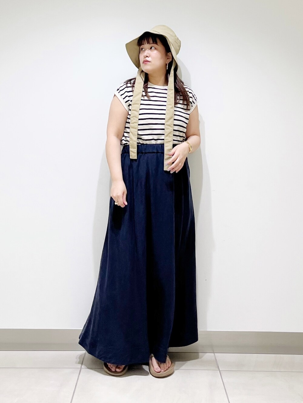 ベージュ系のTシャツ/カットソー、ブルー系のスカート、ベージュ系のサンダルを着用したレディースの夏コーディネートの10枚目の写真