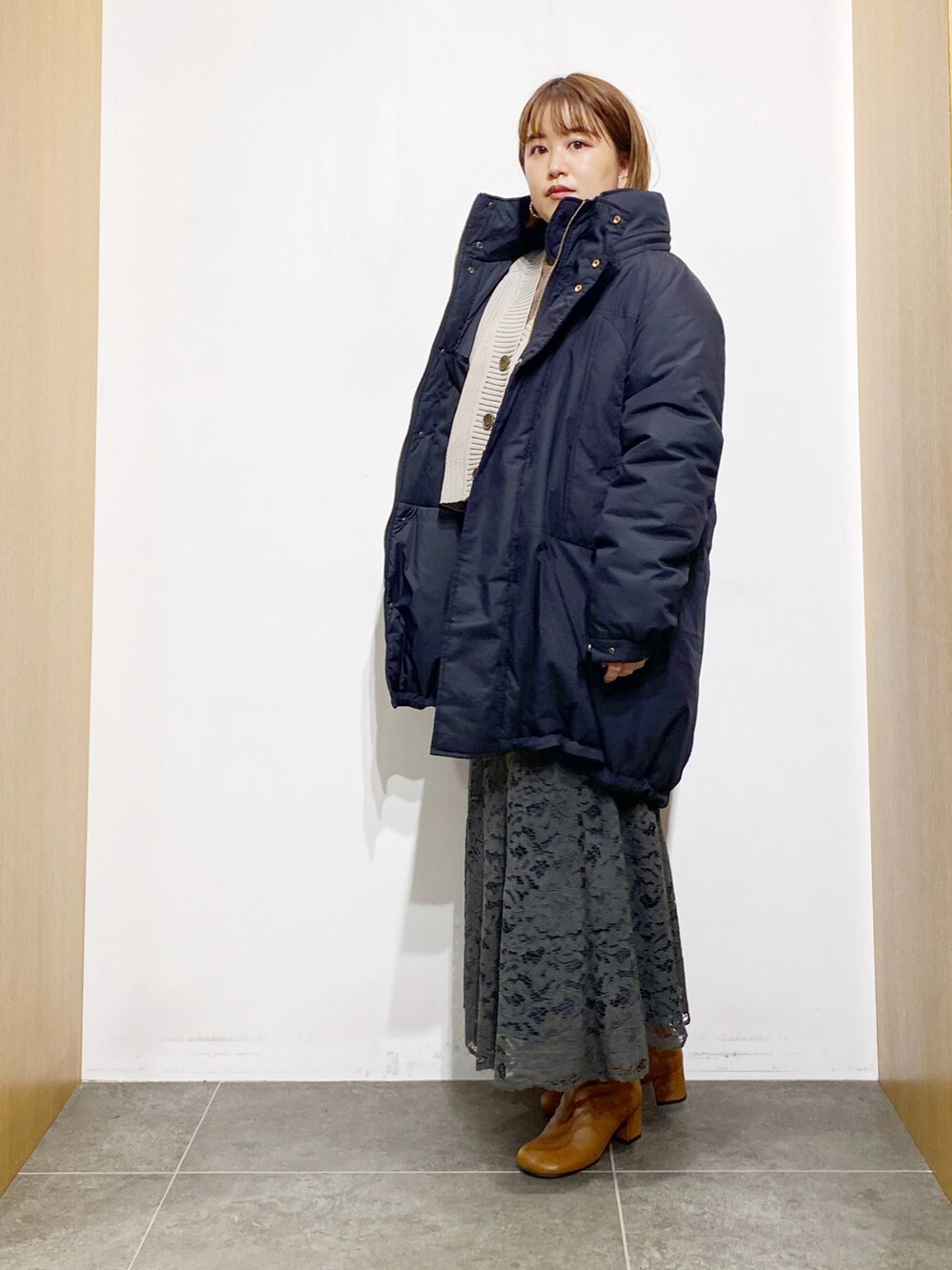 ブラック系のダウンジャケット/コート、ホワイト系のカーディガン/ボレロ、ブラウン系のTシャツ/カットソーを着用したレディースの秋コーディネートの5枚目の写真