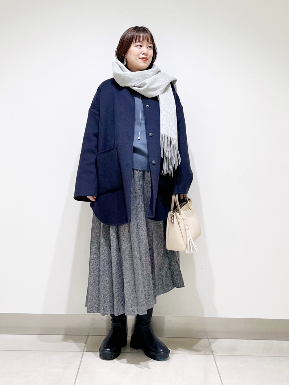 ブルー系のノーカラージャケット、グレー系のニット/セーター、ブルー系のスカートを着用したレディースの秋コーディネートの10枚目の写真