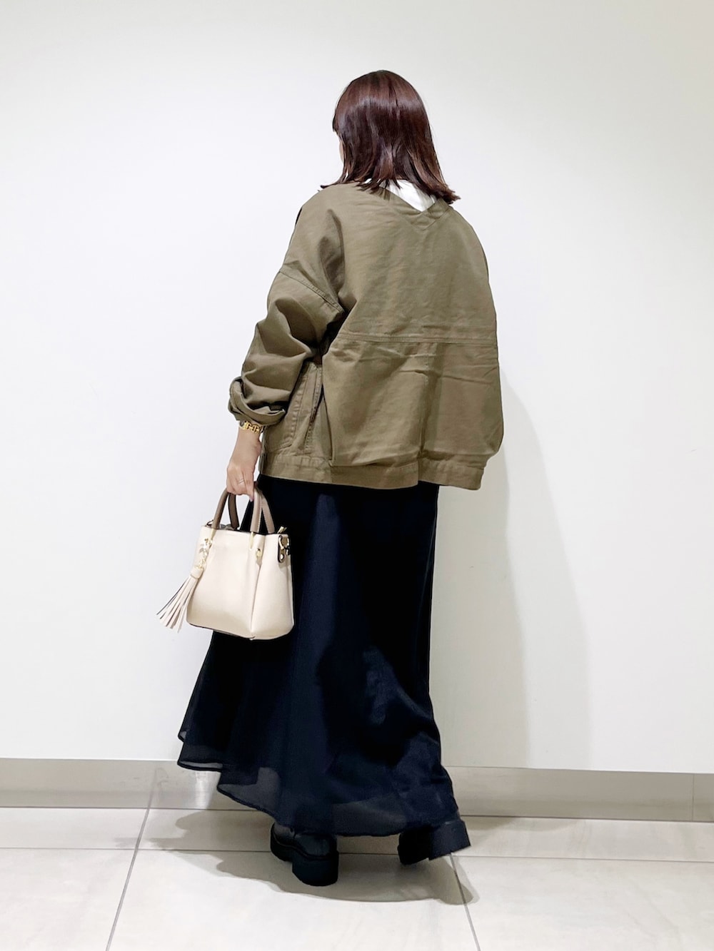 ホワイト系のTシャツ/カットソー、グリーン系のジャケット/アウター、ブラック系のスカートを着用したレディースの夏コーディネートの8枚目の写真