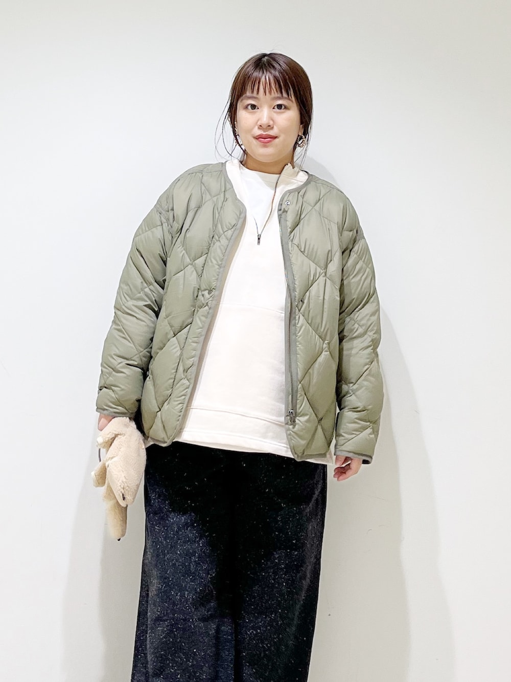 ホワイト系のTシャツ/カットソー、グリーン系のダウンジャケット/コート、ホワイト系のTシャツ/カットソーを着用したレディースの秋コーディネートの3枚目の写真