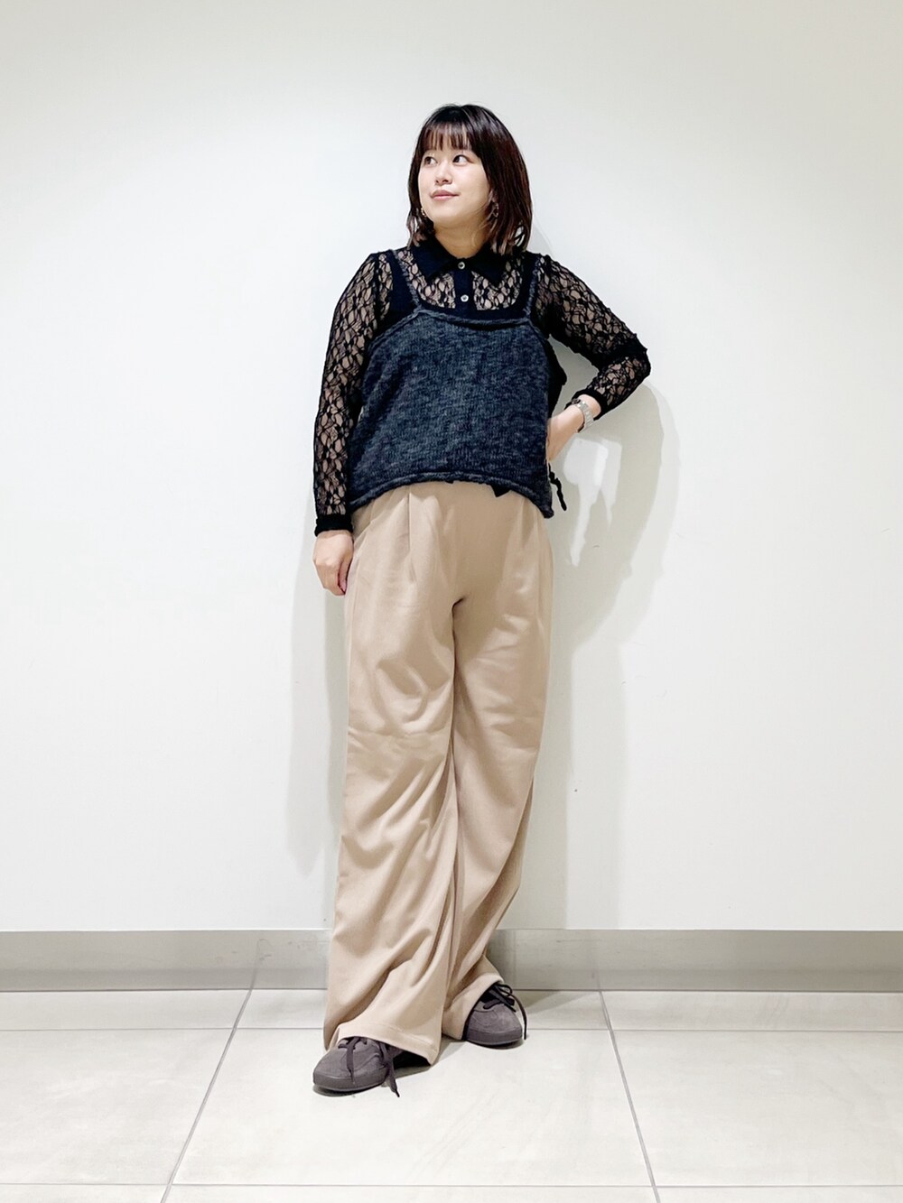 グレー系のニット/セーター、ブラック系のシャツ/ブラウス、ベージュ系のその他パンツを着用したレディースの秋コーディネートの5枚目の写真