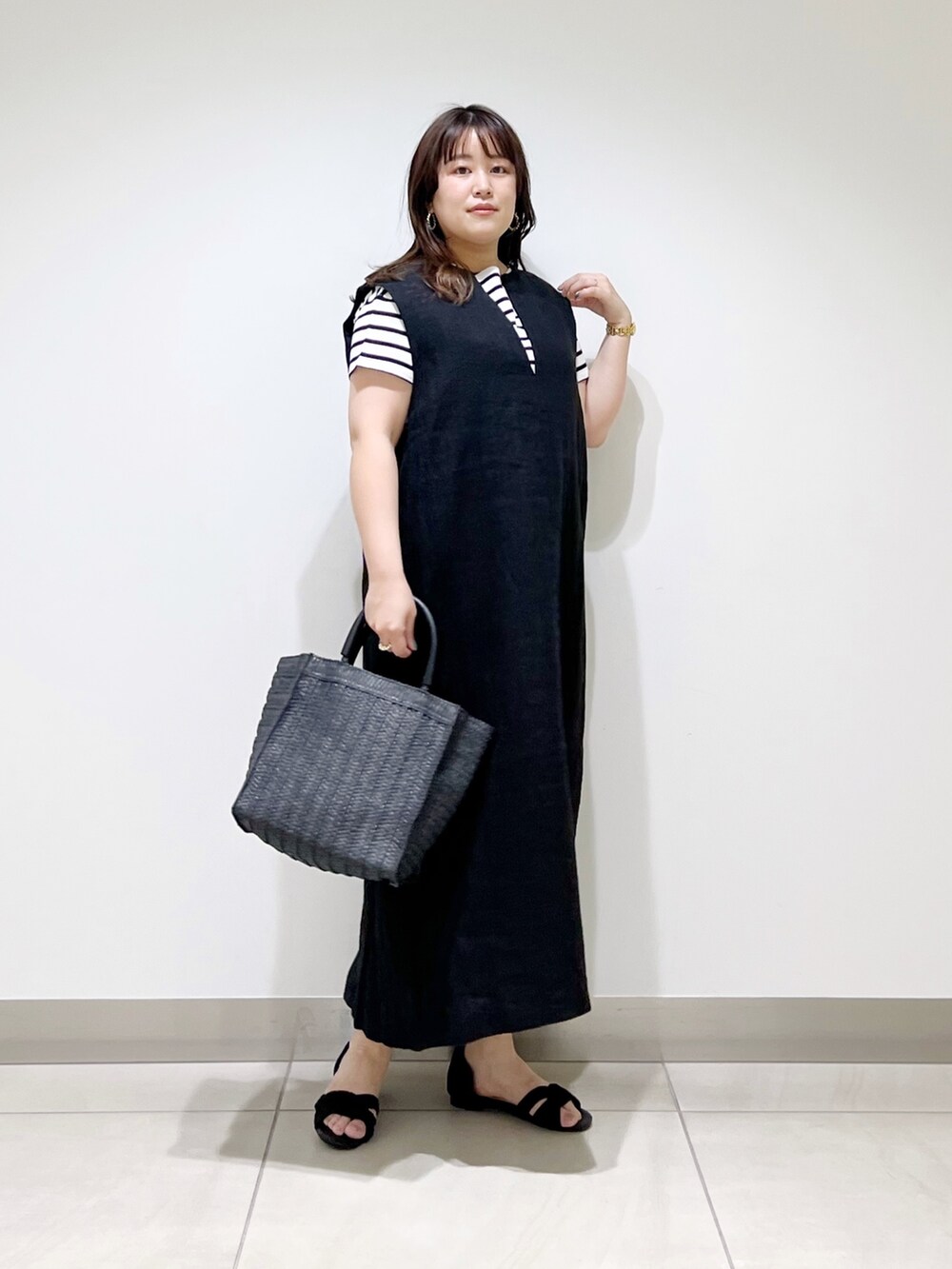 ブラック系のワンピース、ブラック系のTシャツ/カットソー、ブラック系のバッグを着用したレディースの春コーディネートの5枚目の写真