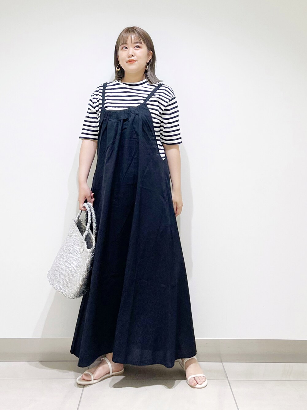 ブラック系のTシャツ/カットソー、ブラック系のワンピース、シルバー系のトートバッグを着用したレディースの春コーディネートの4枚目の写真