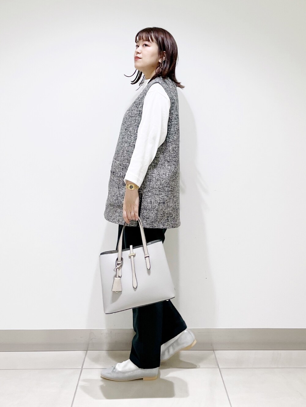 グレー系のトップス、グリーン系のパンツ、グレー系のトートバッグを着用したレディースの夏コーディネートの4枚目の写真
