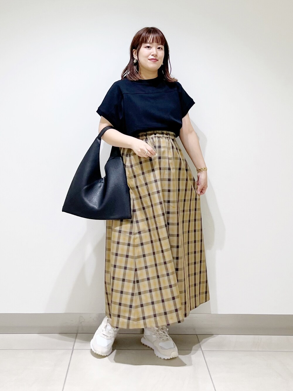 ホワイト系のスニーカー、ブラック系のTシャツ/カットソー、ブラック系のトートバッグを着用したレディースの秋コーディネートの2枚目の写真