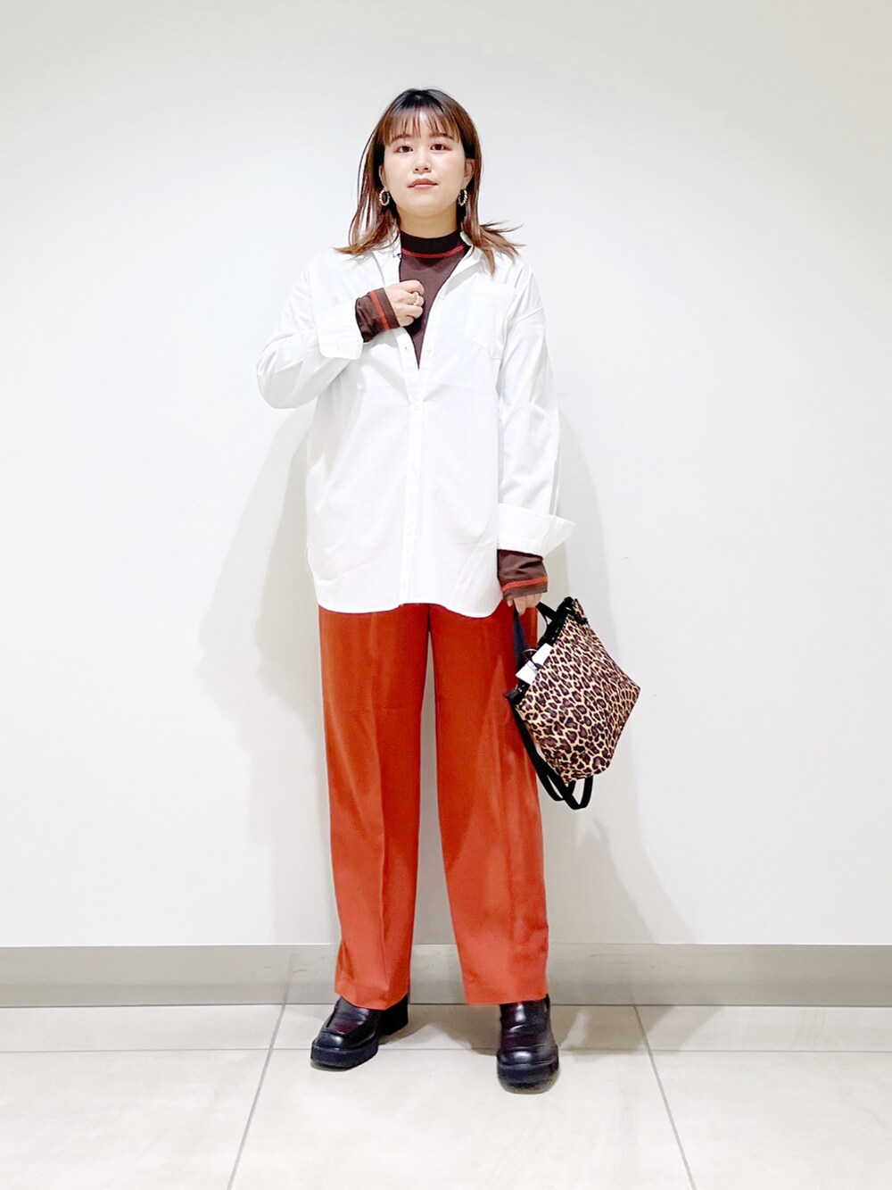 ホワイト系のシャツ/ブラウス、オレンジ系のその他パンツ、その他のショルダーバッグを着用したレディースの秋コーディネートの3枚目の写真