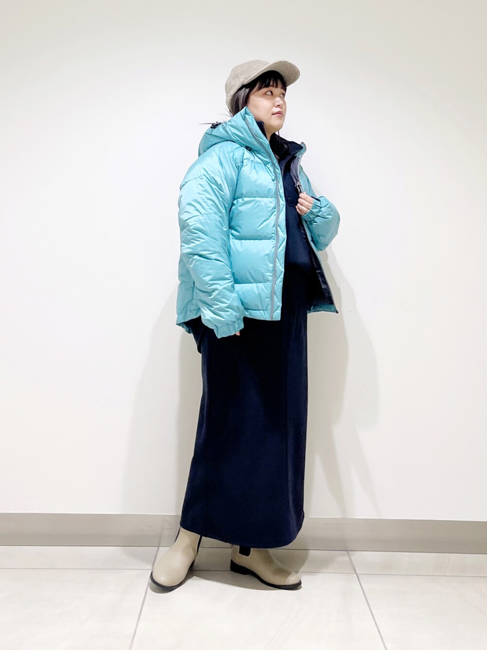 ブルー系のダウンジャケット/コート、ブルー系のTシャツ/カットソー、ブルー系のスカートを着用したレディースの冬コーディネートの2枚目の写真