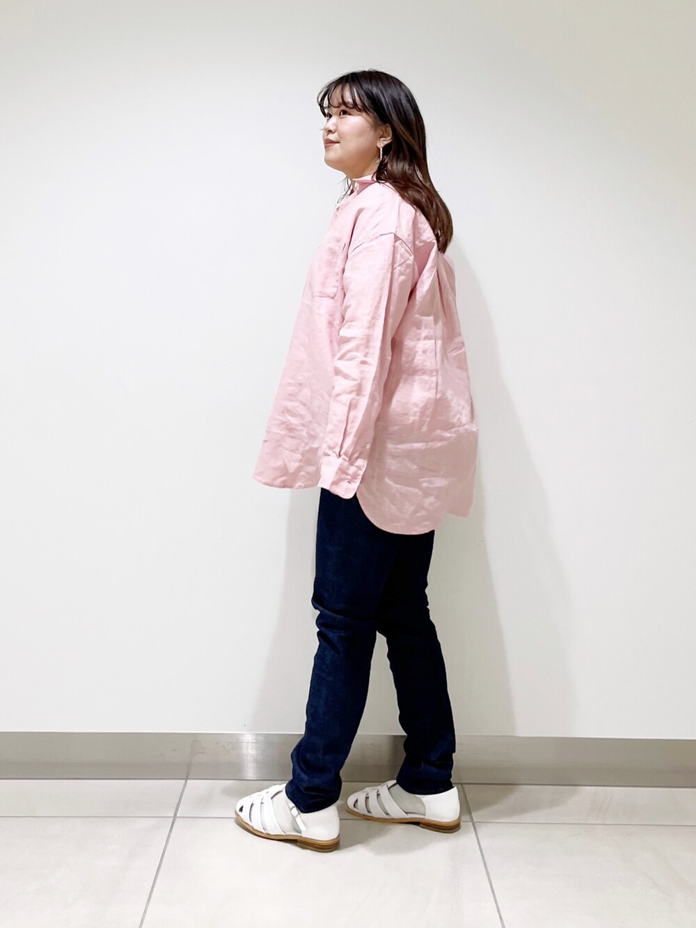 ピンク系のシャツ/ブラウス、ベージュ系のTシャツ/カットソー、ブルー系のデニムパンツを着用したレディースの春コーディネートの2枚目の写真