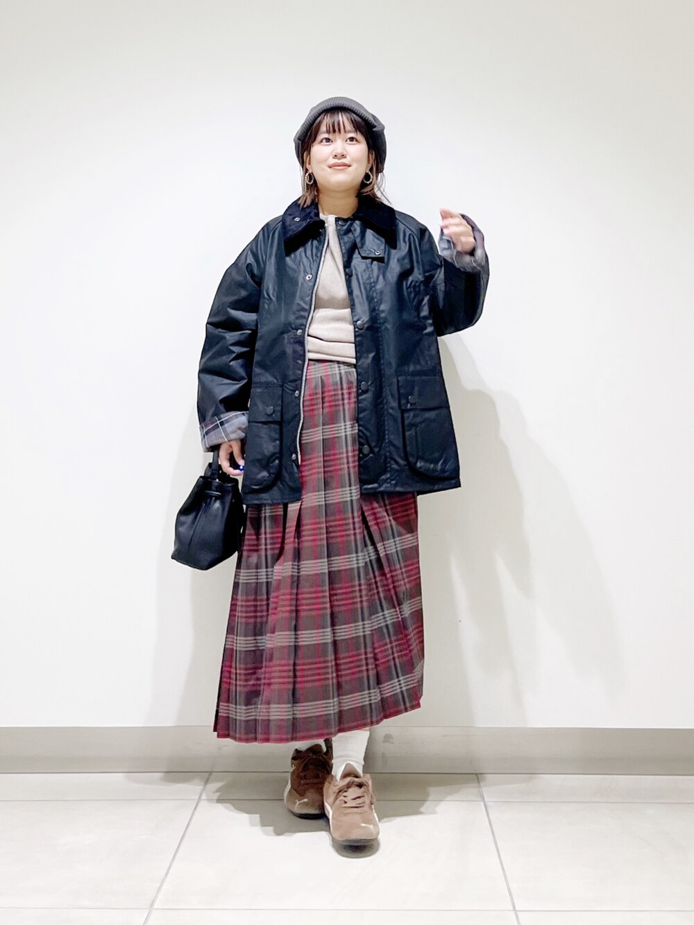 ブラック系のテーラードジャケット、グレー系のTシャツ/カットソー、ブラウン系のスカートを着用したレディースの秋コーディネートの8枚目の写真