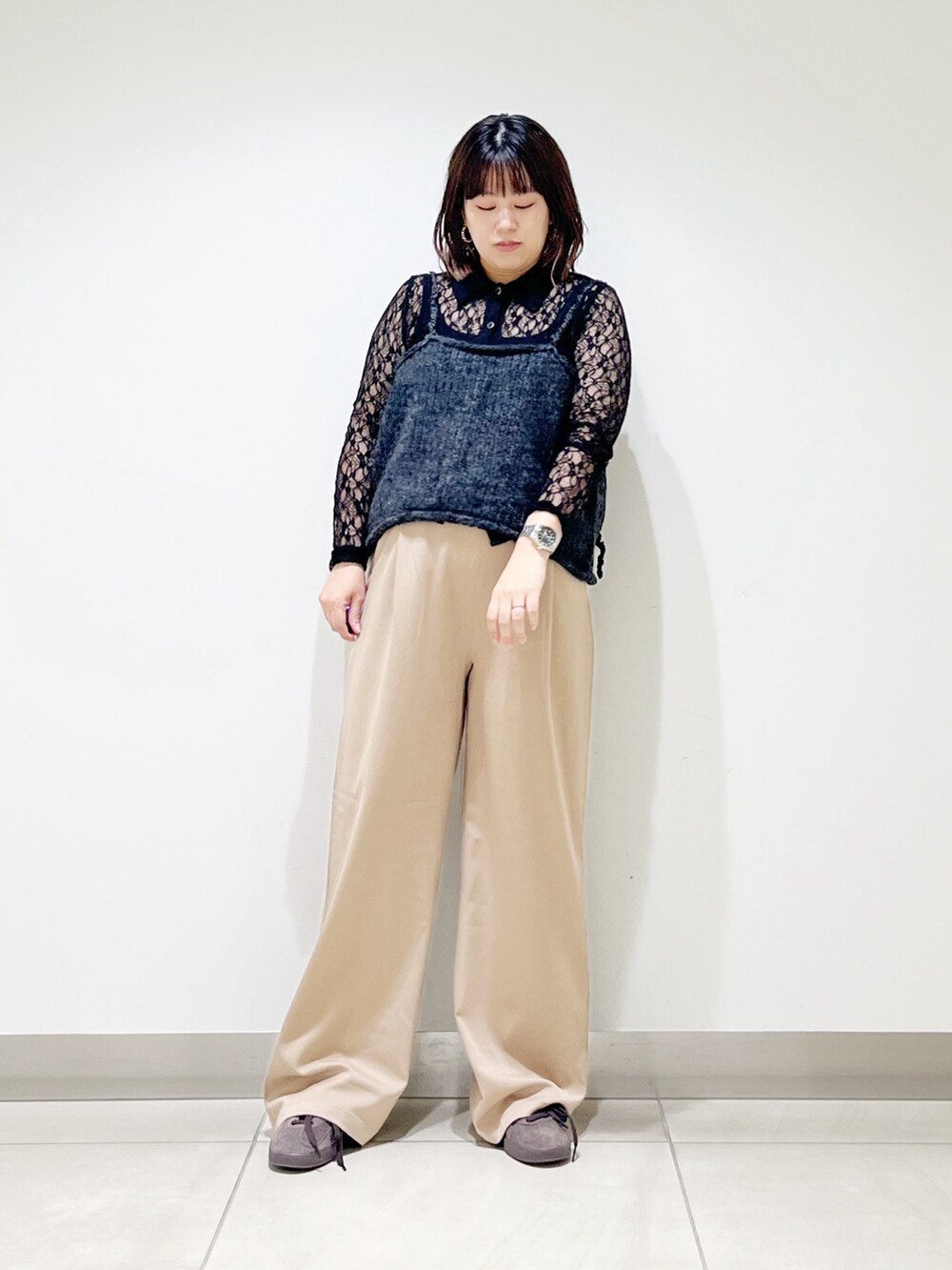 グレー系のニット/セーター、ブラック系のシャツ/ブラウス、ベージュ系のその他パンツを着用したレディースの秋コーディネートの3枚目の写真