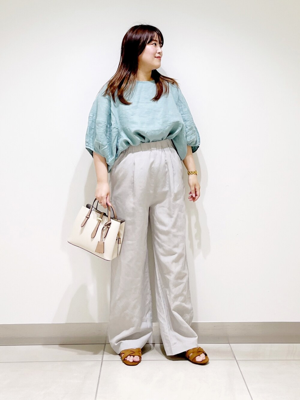 グリーン系のシャツ/ブラウス、ベージュ系のその他パンツ、ホワイト系のトートバッグを着用したレディースの夏コーディネートの5枚目の写真
