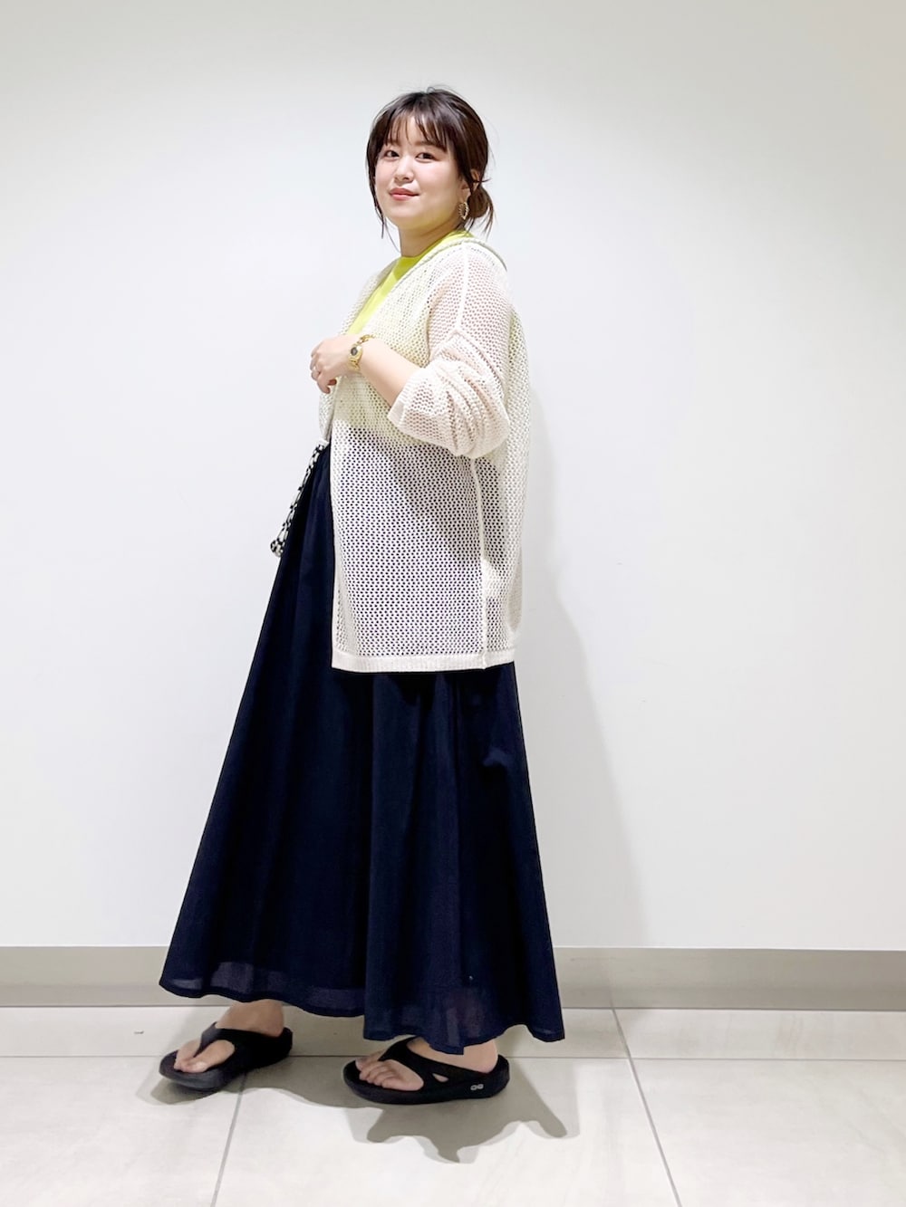 ホワイト系のカーディガン/ボレロ、ブラック系のショルダーバッグ、ブルー系のスカートを着用したレディースの春コーディネートの2枚目の写真