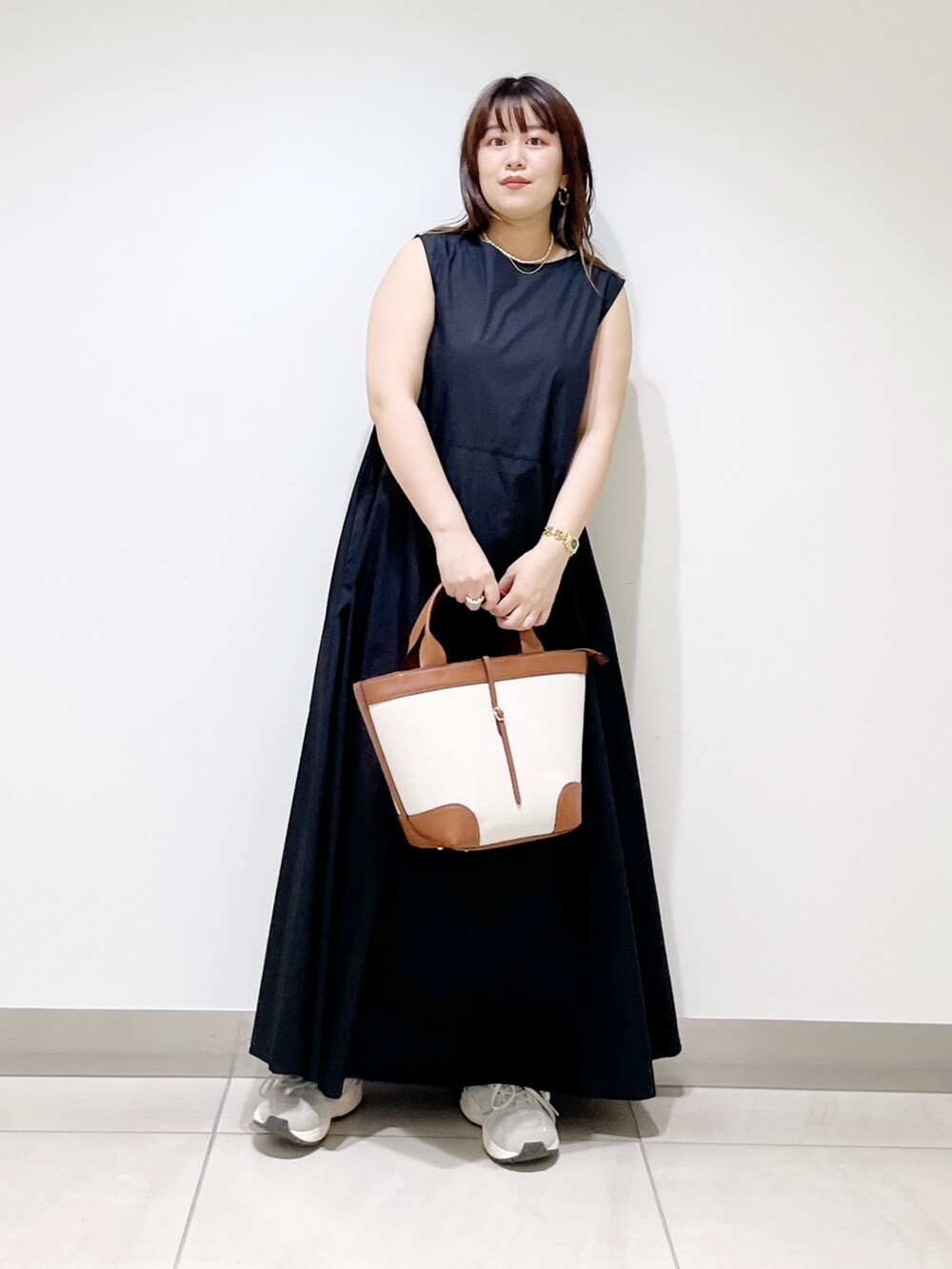 ブラック系のワンピース/ドレス、イエロー系のトートバッグ、グレー系のスニーカーを着用したレディースの夏コーディネートの2枚目の写真