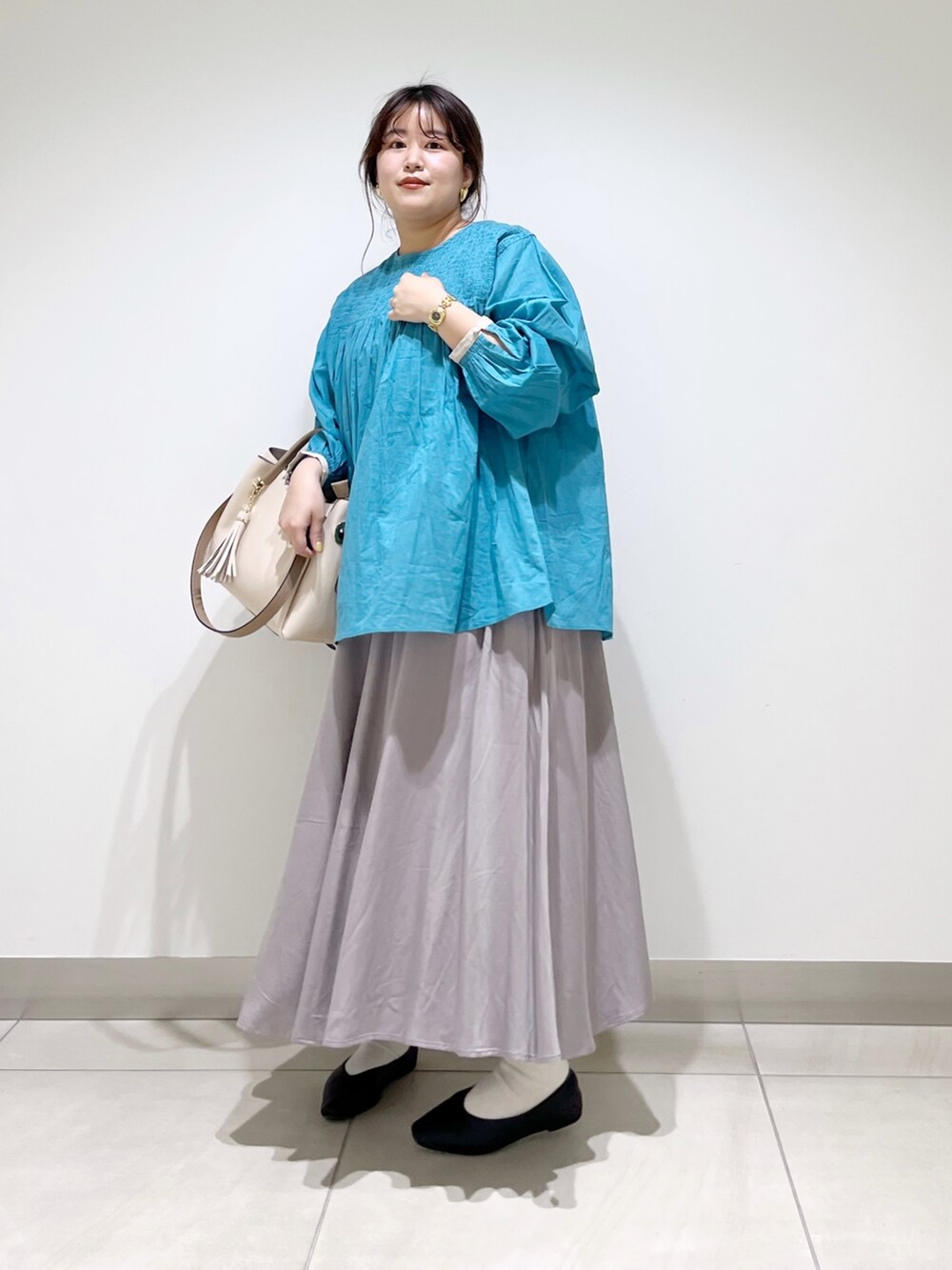 ブルー系のシャツ/ブラウス、グレー系のスカート、ホワイト系のトートバッグを着用したレディースの春コーディネートの3枚目の写真