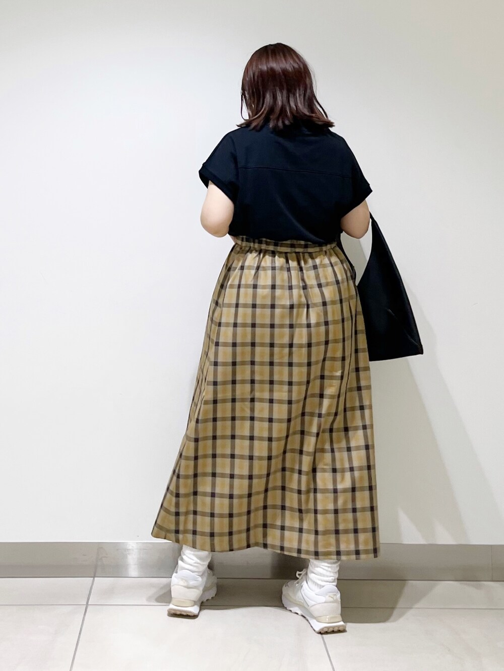 ホワイト系のスニーカー、ブラック系のTシャツ/カットソー、ブラック系のトートバッグを着用したレディースの秋コーディネートの6枚目の写真