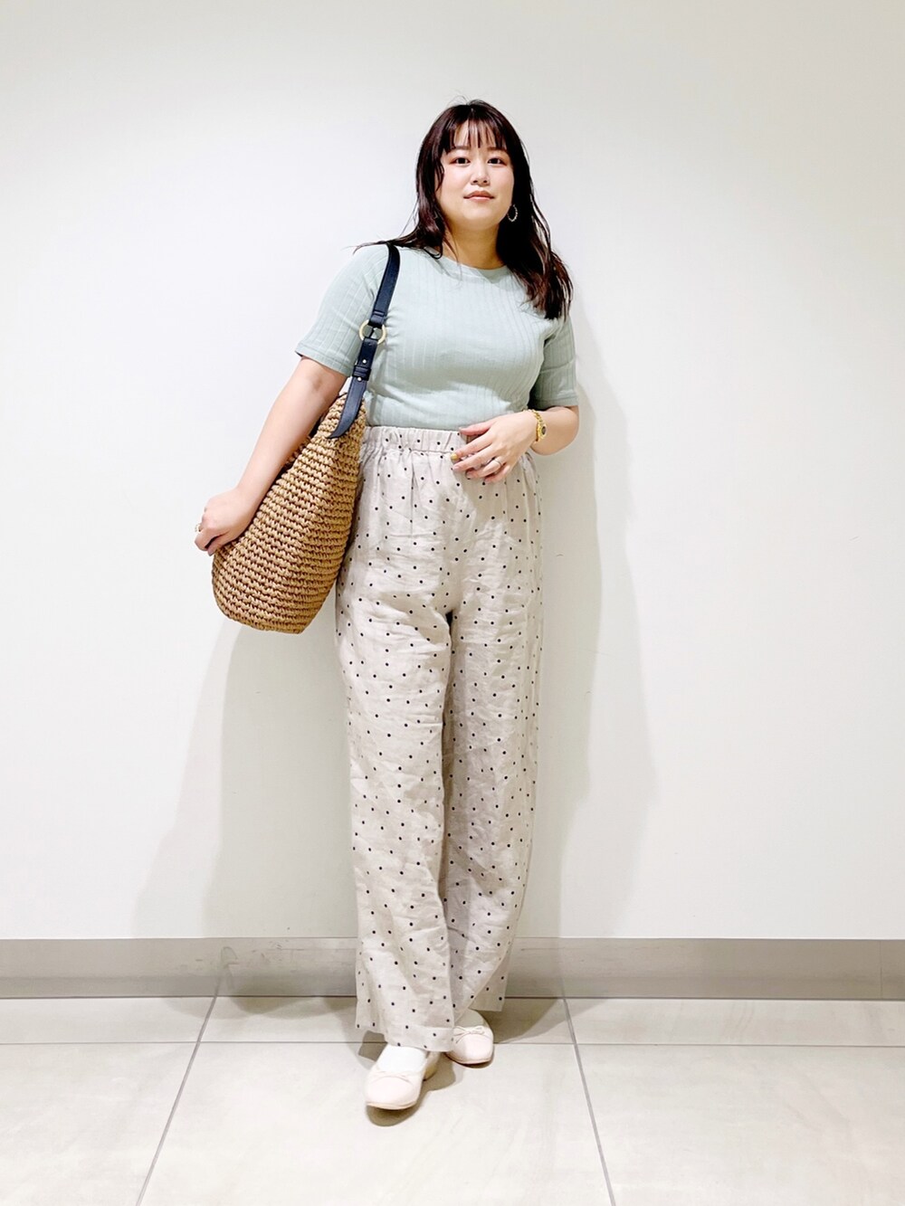 グリーン系のTシャツ/カットソー、ベージュ系のその他パンツ、ブラウン系のバッグを着用したレディースの春コーディネートの2枚目の写真