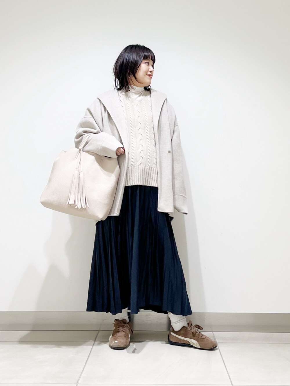 ベージュ系のその他アウター、ベージュ系のニット/セーター、ホワイト系のトートバッグを着用したレディースの秋コーディネートの7枚目の写真