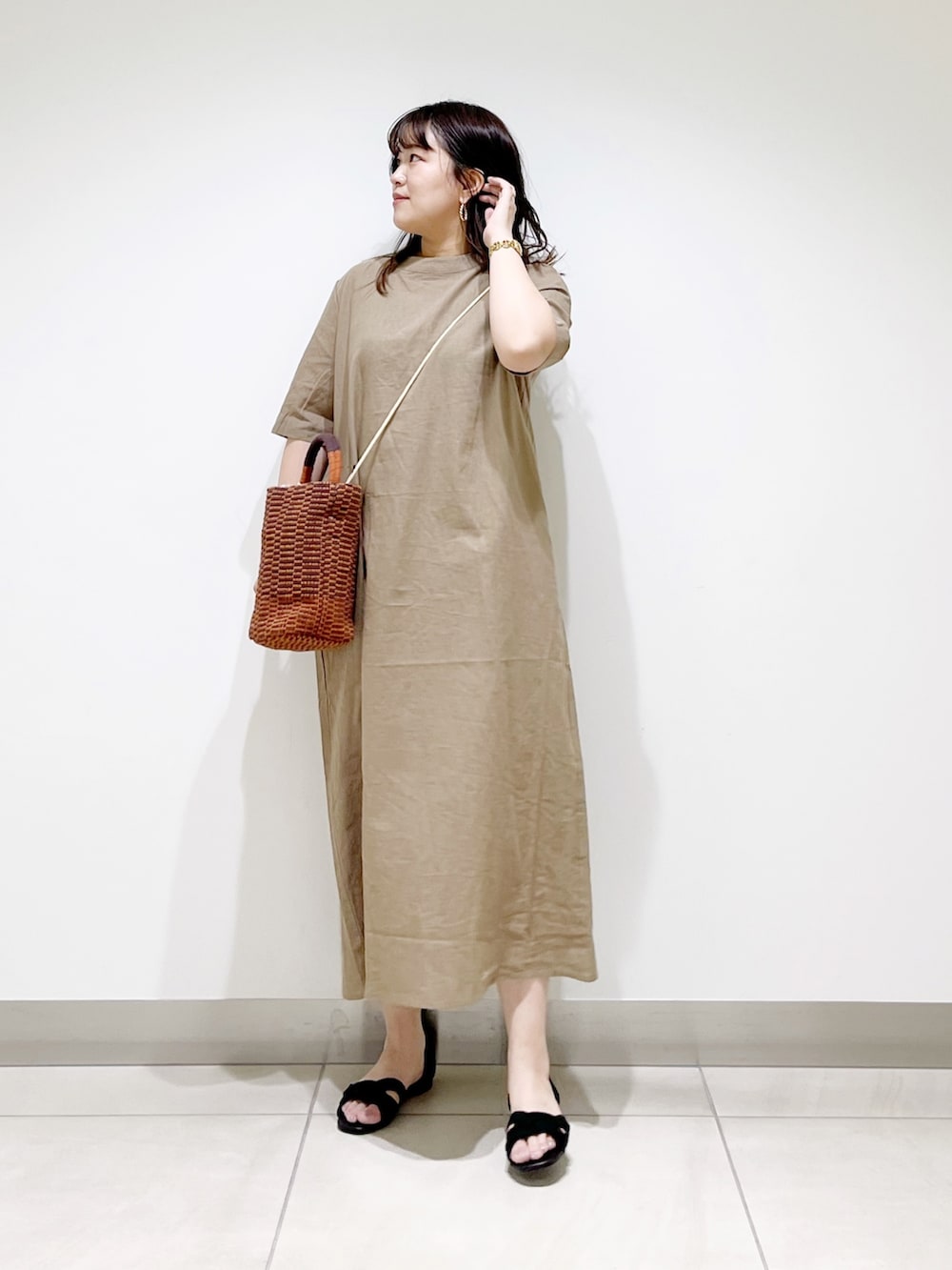 ベージュ系のワンピース、ブラウン系のショルダーバッグ、ブラック系のサンダルを着用したレディースの春コーディネートの2枚目の写真