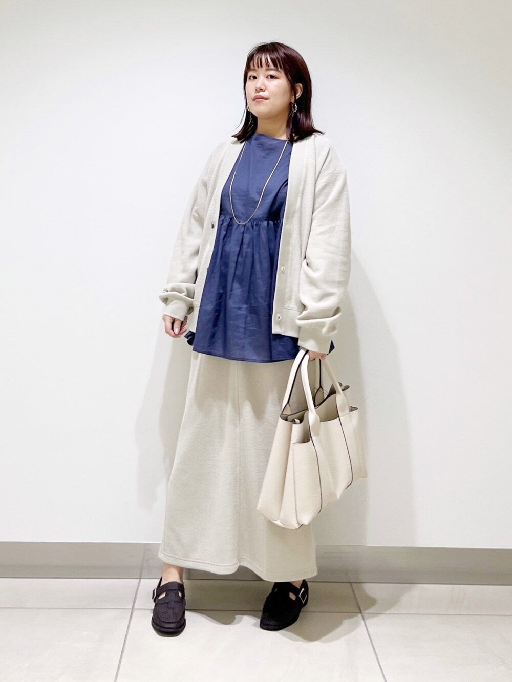 ブルー系のシャツ/ブラウス、ベージュ系のカーディガン/ボレロ、ベージュ系のスカートを着用したレディースの夏コーディネートの4枚目の写真