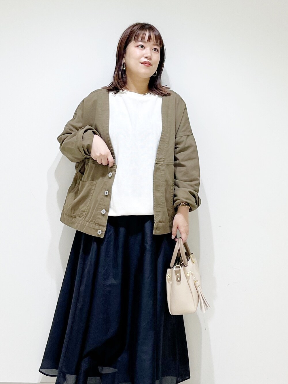 ホワイト系のTシャツ/カットソー、グリーン系のジャケット/アウター、ブラック系のスカートを着用したレディースの夏コーディネートの5枚目の写真