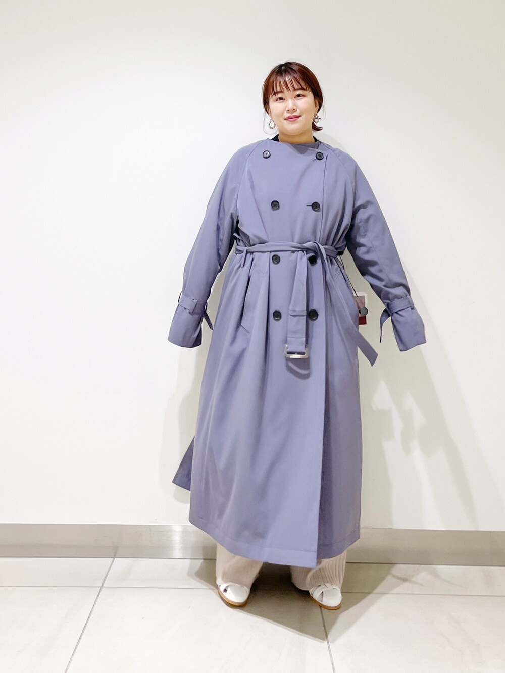 ブルー系のトレンチコート、ホワイト系のサンダル、ベージュ系のその他パンツを着用したレディースの冬コーディネートの3枚目の写真