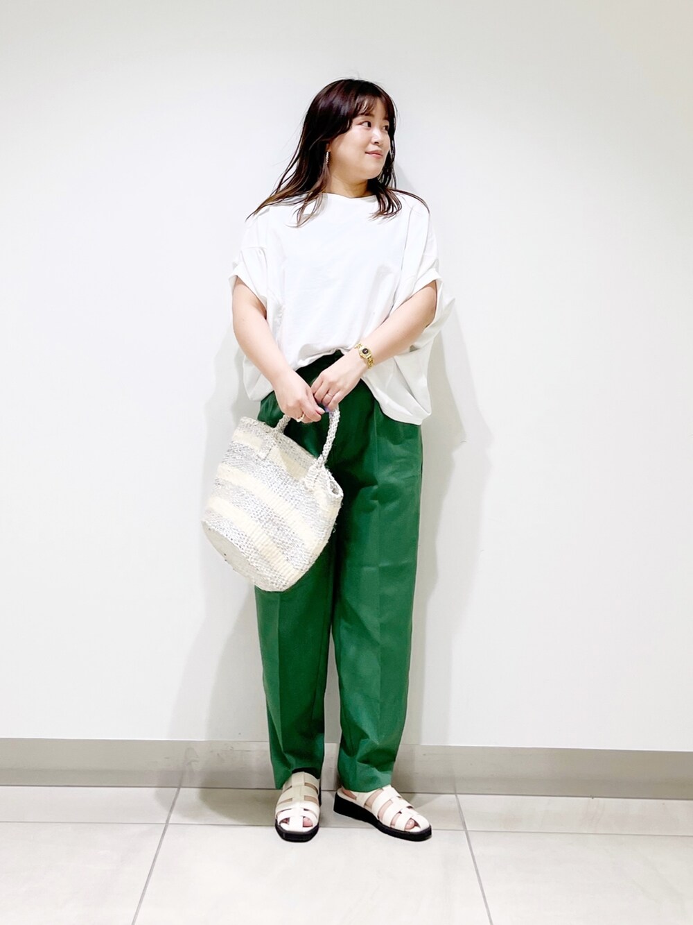 グリーン系のその他パンツ、ホワイト系のTシャツ/カットソー、ホワイト系のハンドバッグを着用したレディースの春コーディネートの7枚目の写真