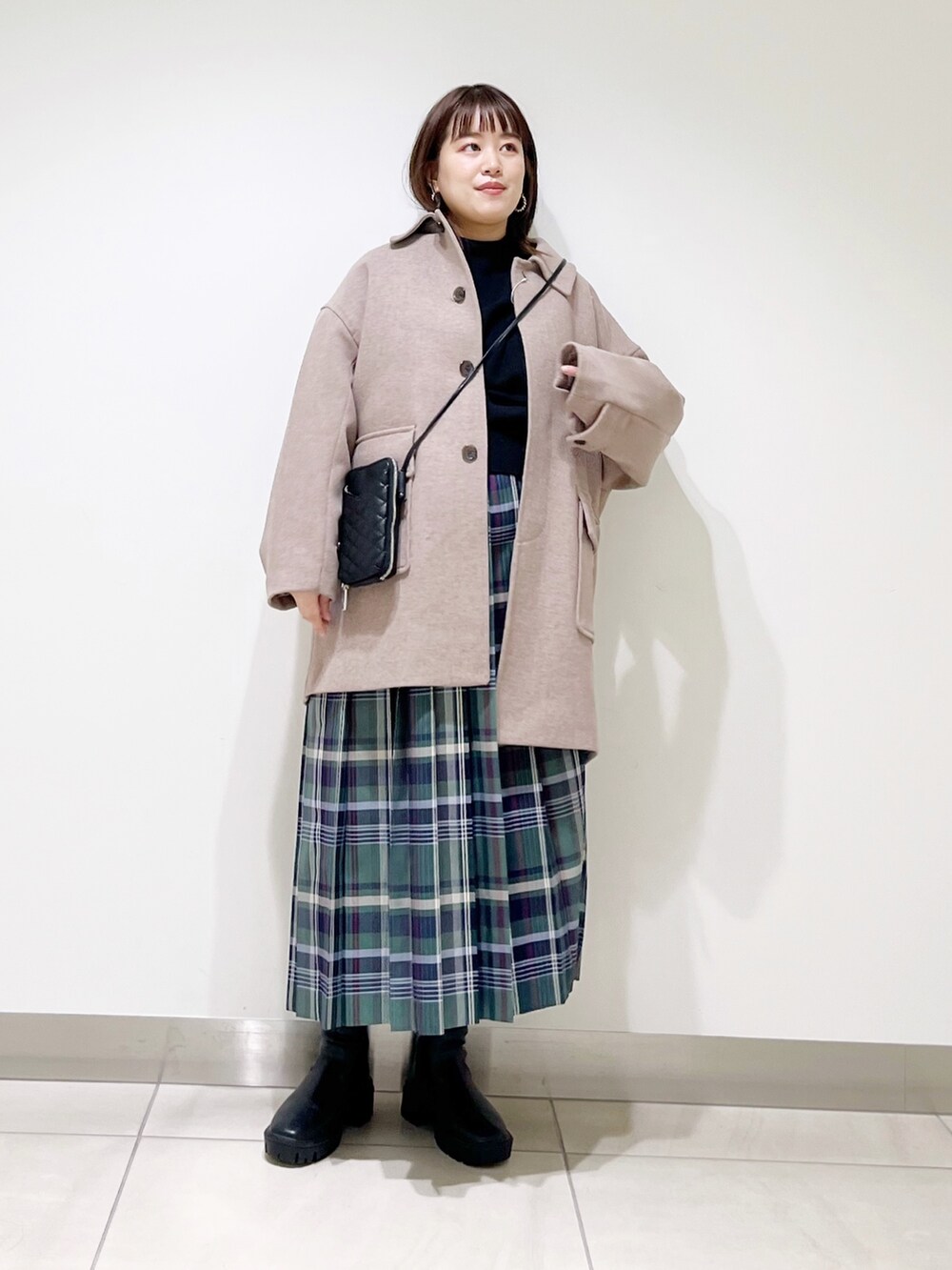ブラウン系のその他アウター、ブラック系のニット/セーター、グリーン系のスカートを着用したレディースの秋コーディネートの10枚目の写真