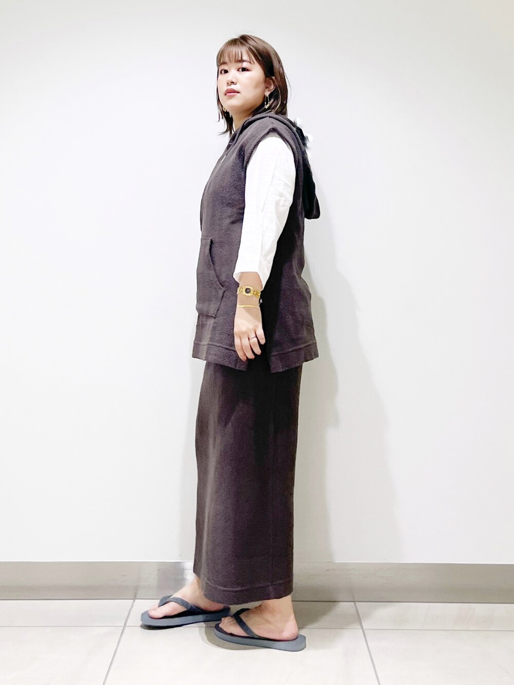 ブラウン系のパーカー、ブラウン系のスカート、グレー系のサンダルを着用したレディースの春コーディネートの3枚目の写真