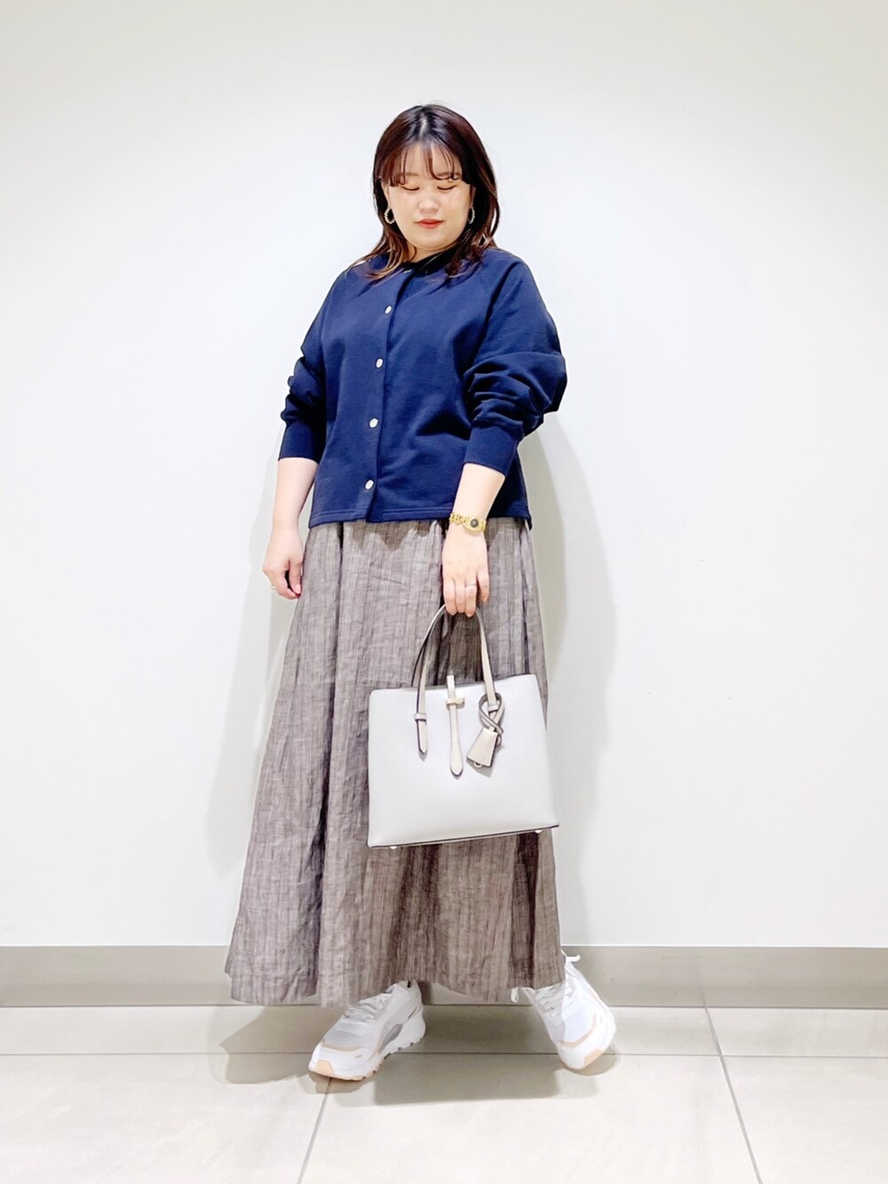 ブルー系のカーディガン/ボレロ、グレー系のトートバッグ、ブラウン系のスカートを着用したレディースの春コーディネートの5枚目の写真