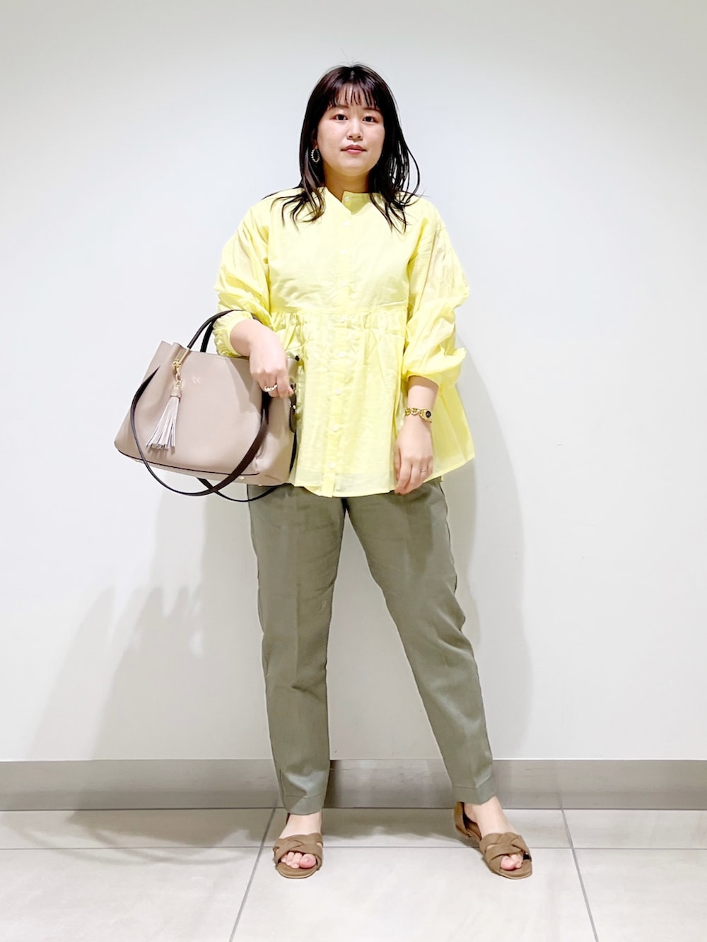 イエロー系のシャツ/ブラウス、グリーン系のその他パンツ、ベージュ系のトートバッグを着用したレディースの春コーディネートの8枚目の写真