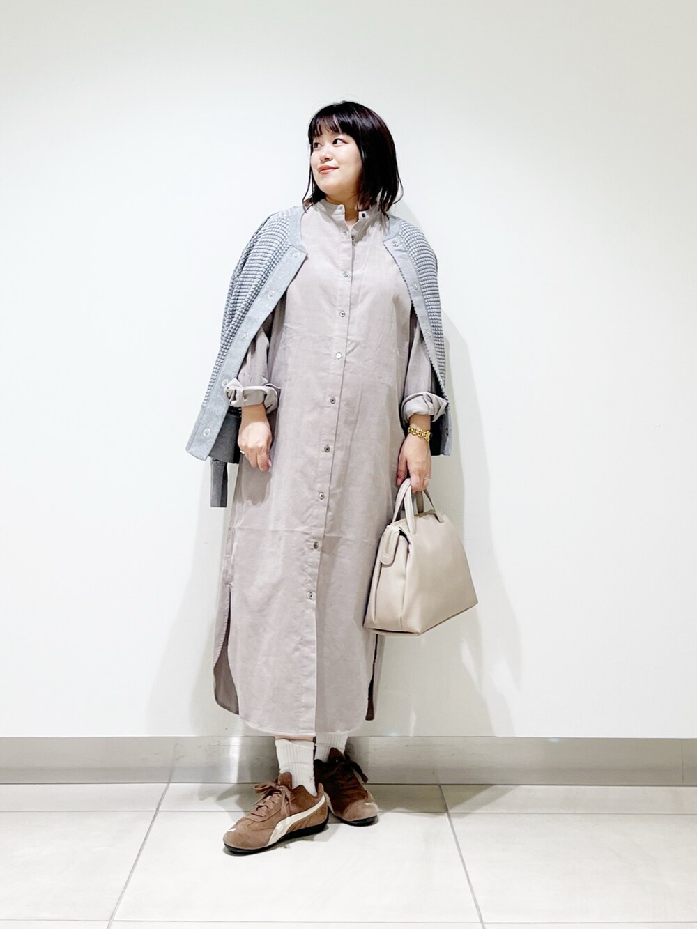 ベージュ系のワンピース、グレー系のカーディガン/ボレロ、グレー系のボストンバッグを着用したレディースの秋コーディネートの2枚目の写真