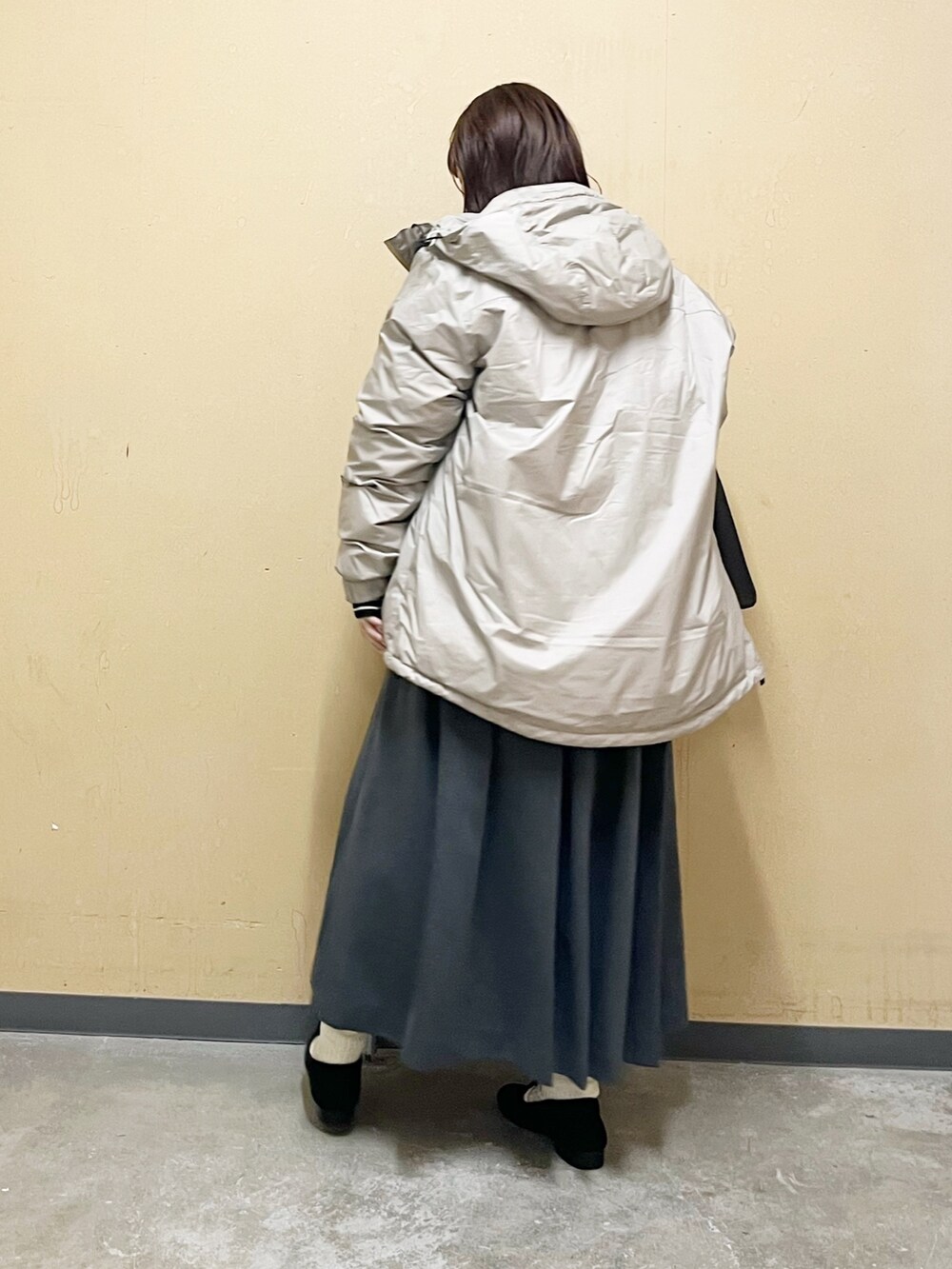 ベージュ系のダウンジャケット/コート、ブラック系のニット/セーター、グレー系のワンピース/ドレスを着用したレディースの秋コーディネートの6枚目の写真