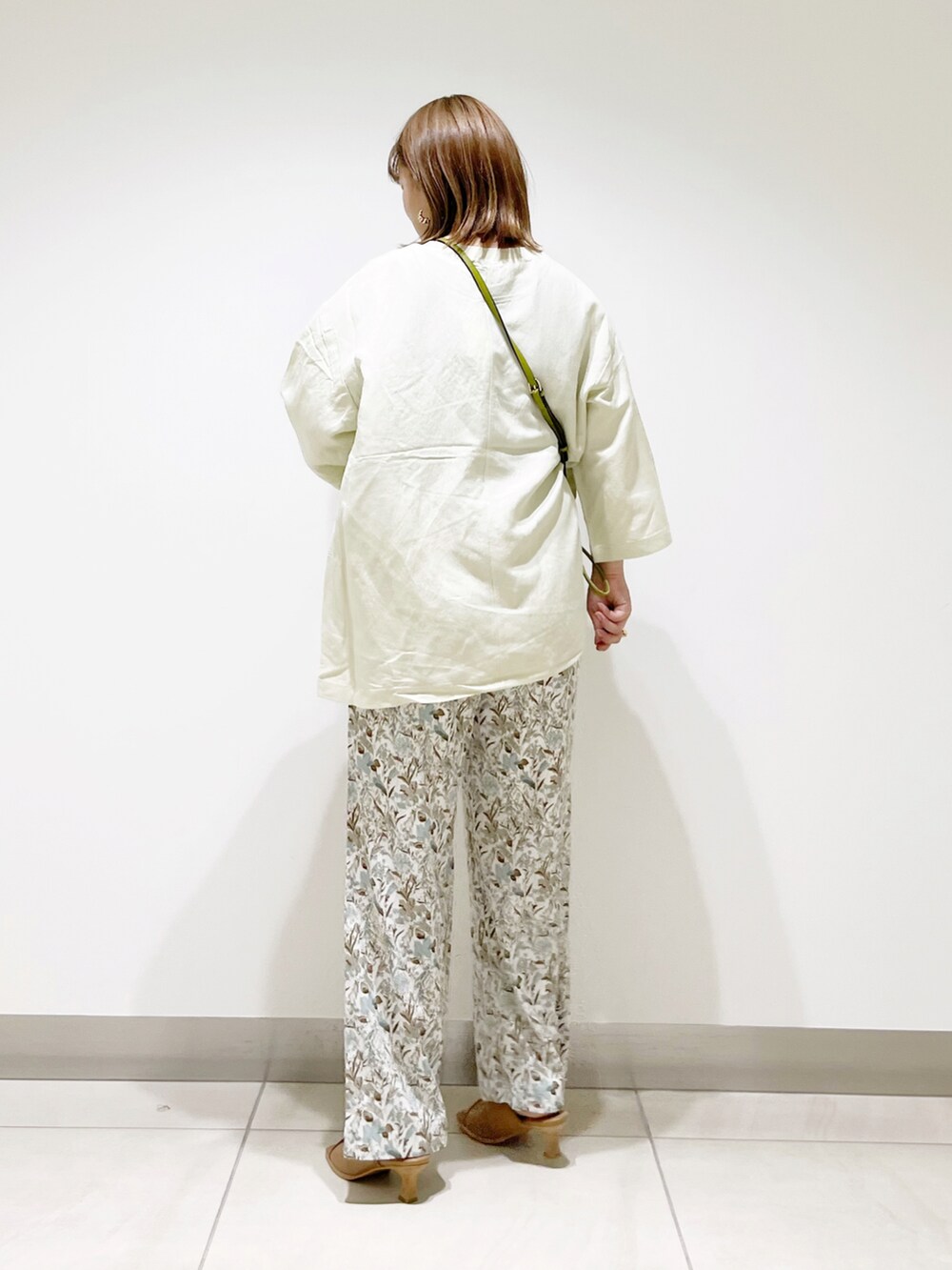 ホワイト系のその他パンツ、グリーン系のショルダーバッグ、ベージュ系のTシャツ/カットソーを着用したレディースの春コーディネートの4枚目の写真