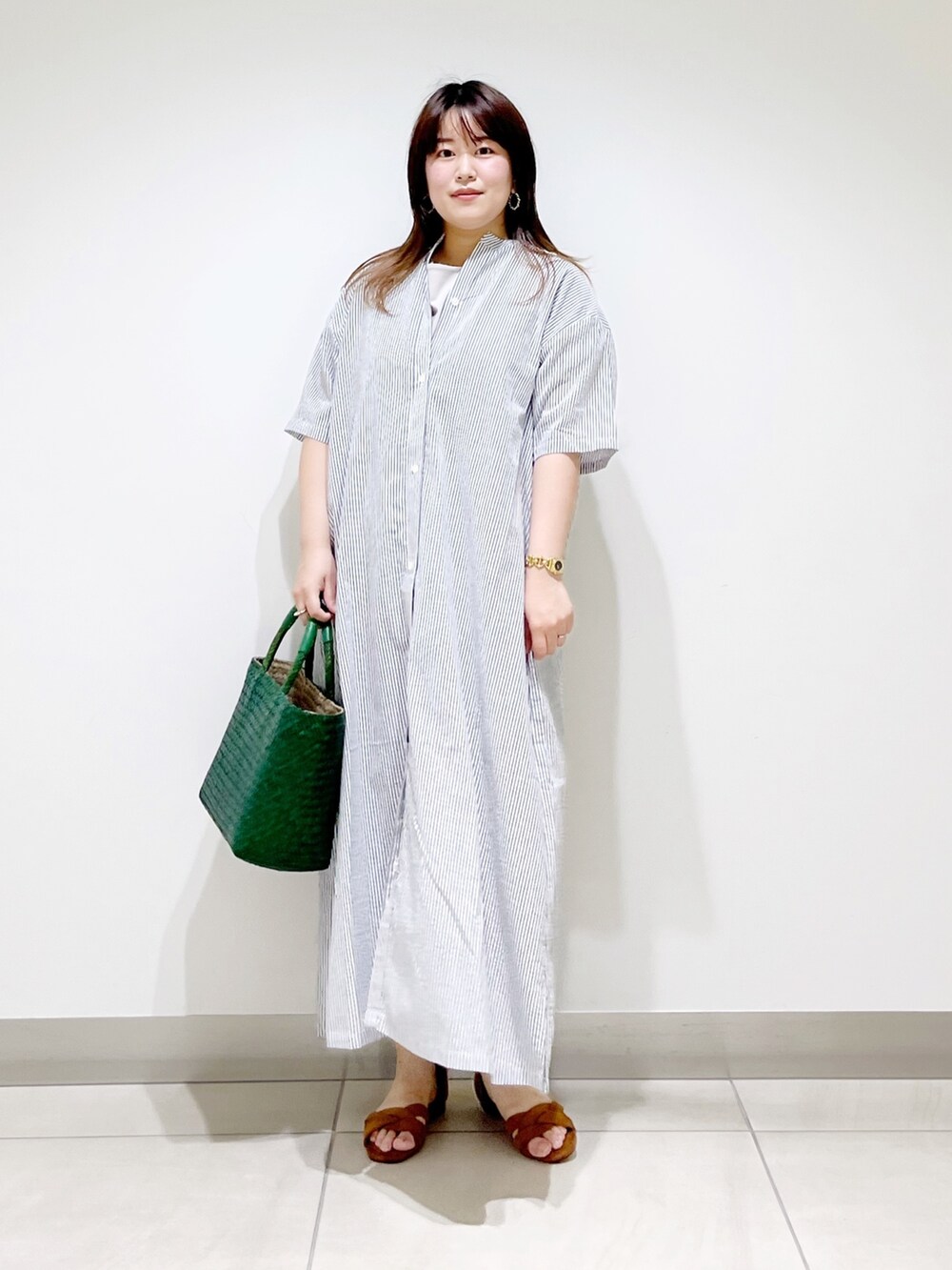 ブラック系のワンピース、グレー系のTシャツ/カットソー、グリーン系のハンドバッグを着用したレディースの夏コーディネートの2枚目の写真