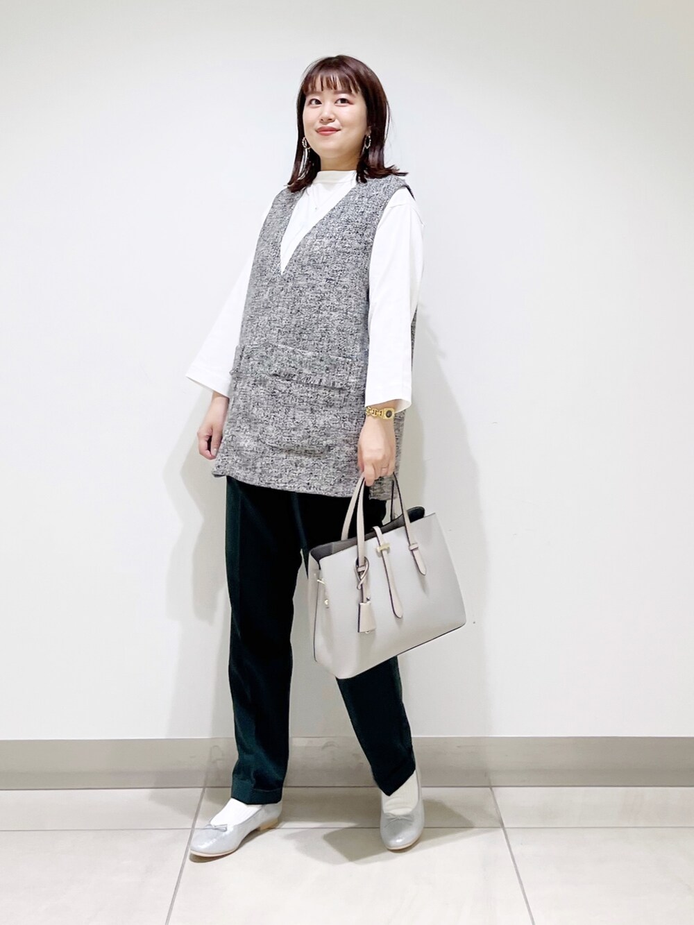 グレー系のトップス、グリーン系のパンツ、グレー系のトートバッグを着用したレディースの夏コーディネートの6枚目の写真