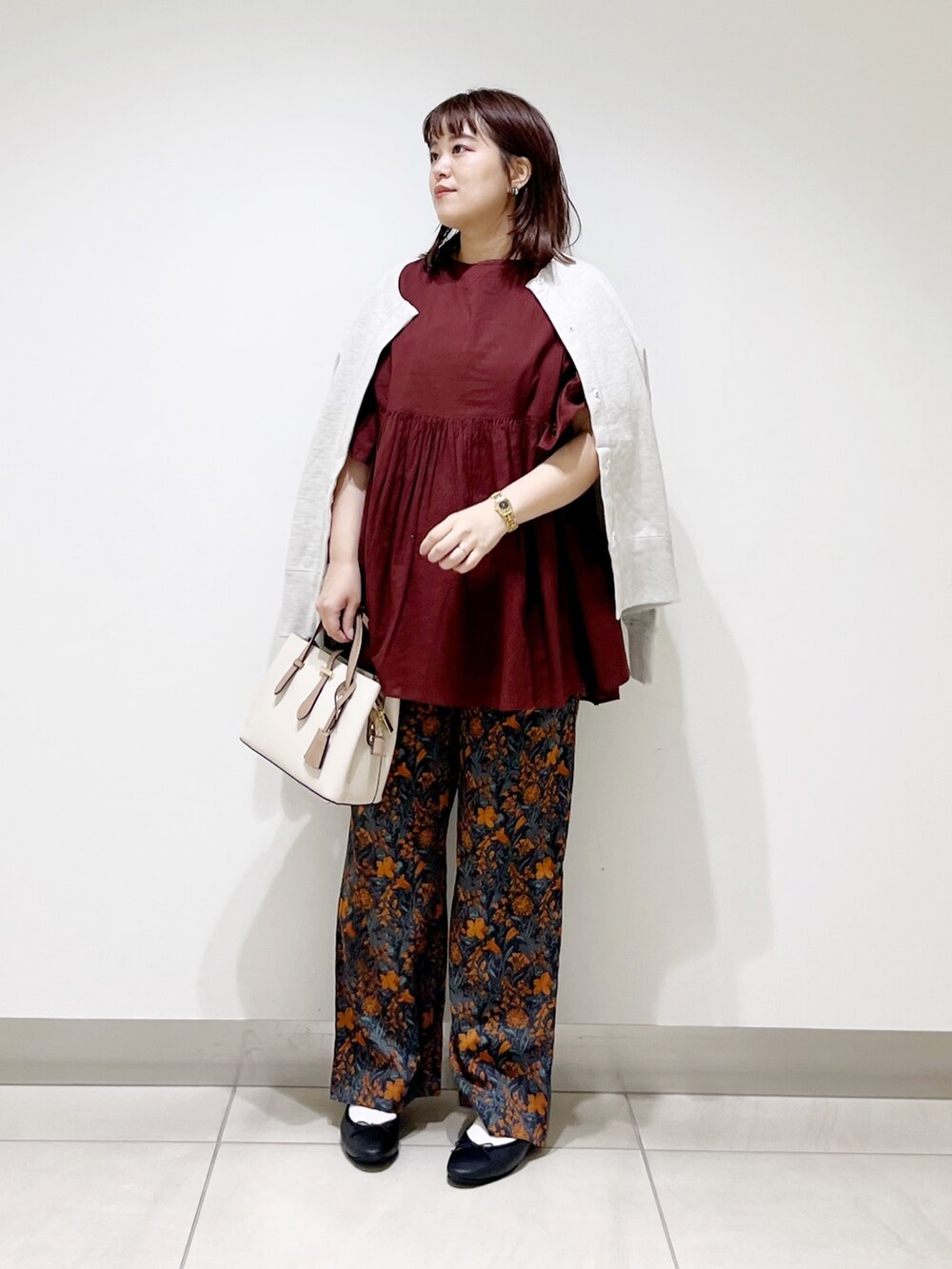 オレンジ系のその他パンツ、レッド系のシャツ/ブラウス、グレー系のカーディガン/ボレロを着用したレディースの秋コーディネートの6枚目の写真