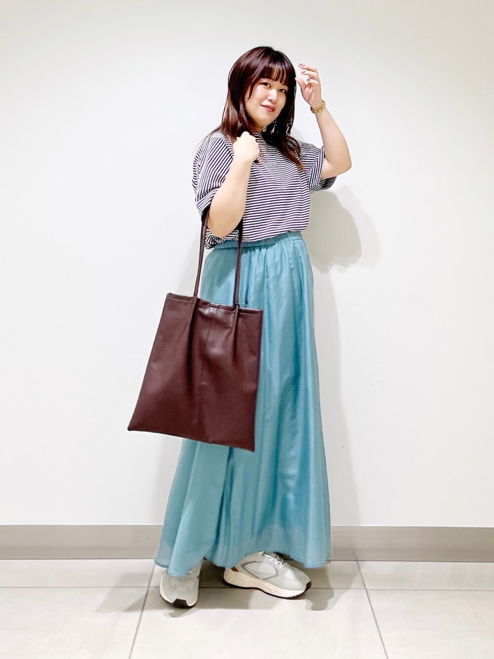 ホワイト系のTシャツ/カットソー、ホワイト系のスカート、ブラウン系のトートバッグを着用したレディースの夏コーディネートの2枚目の写真