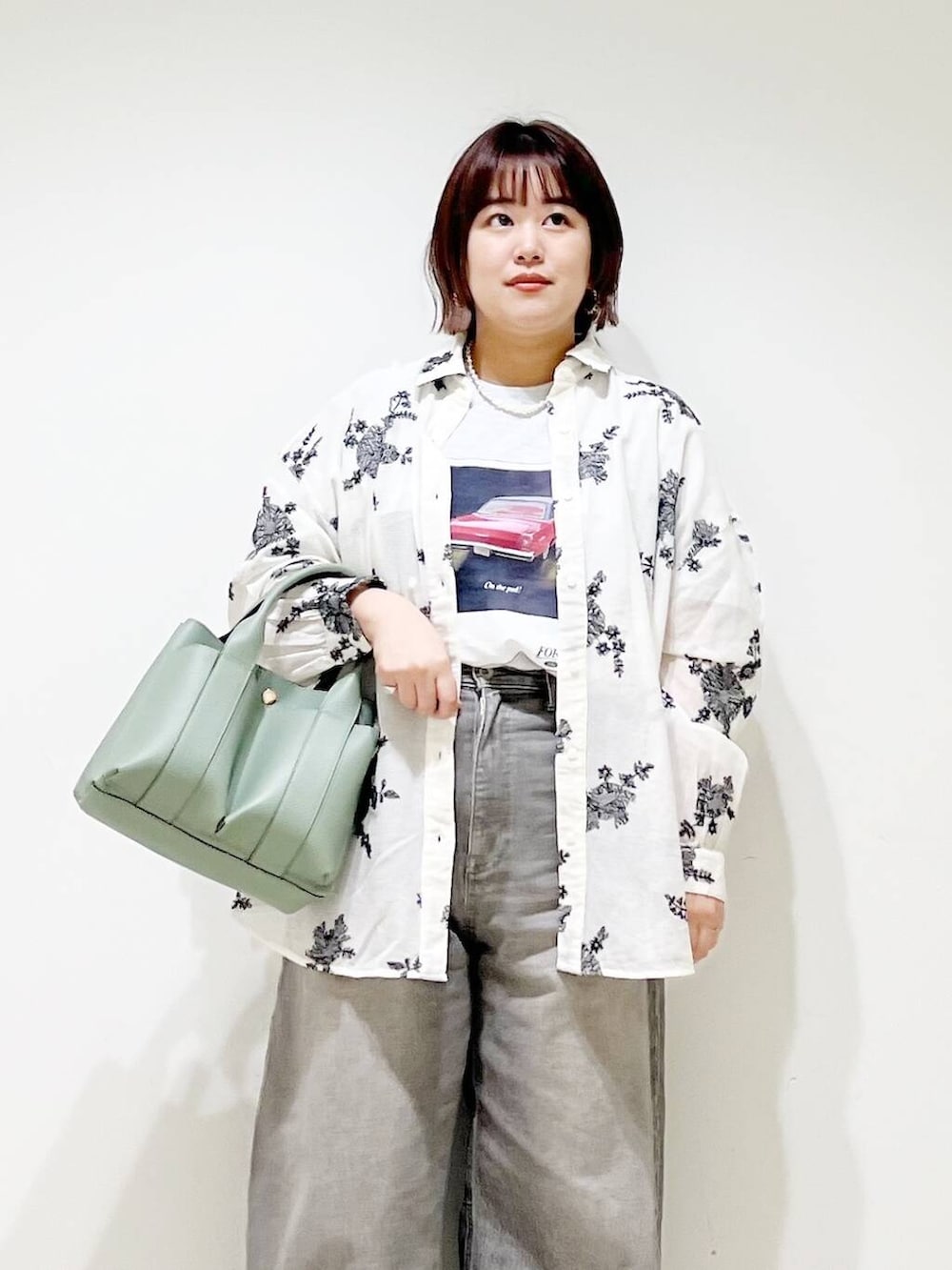 グリーン系のデニムパンツ、グリーン系のトートバッグ、シルバー系のパンプスを着用したレディースの春コーディネートの3枚目の写真