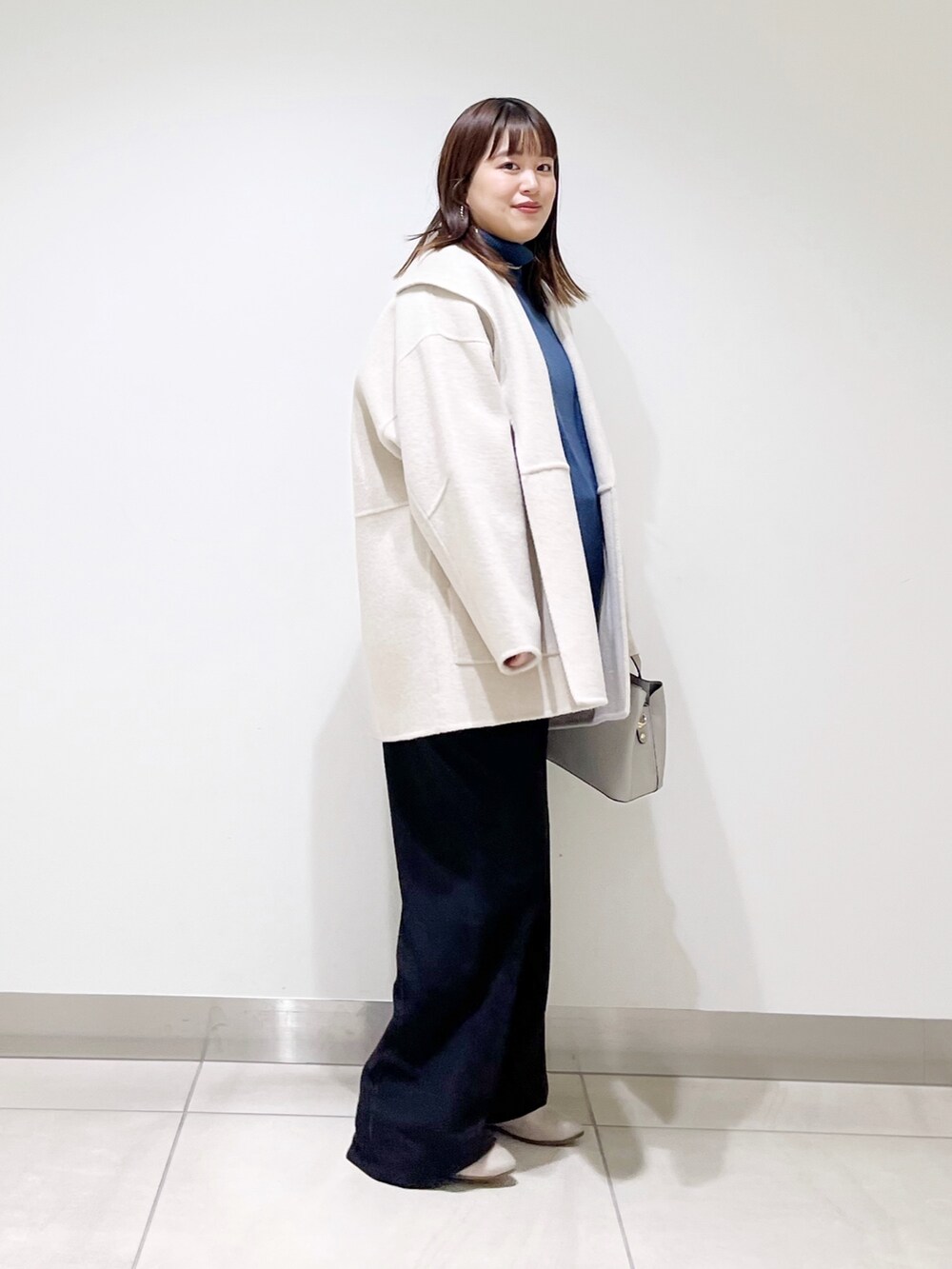 ベージュ系のその他アウター、ブルー系のニット/セーター、ブラック系のパンプスを着用したレディースの冬コーディネートの4枚目の写真