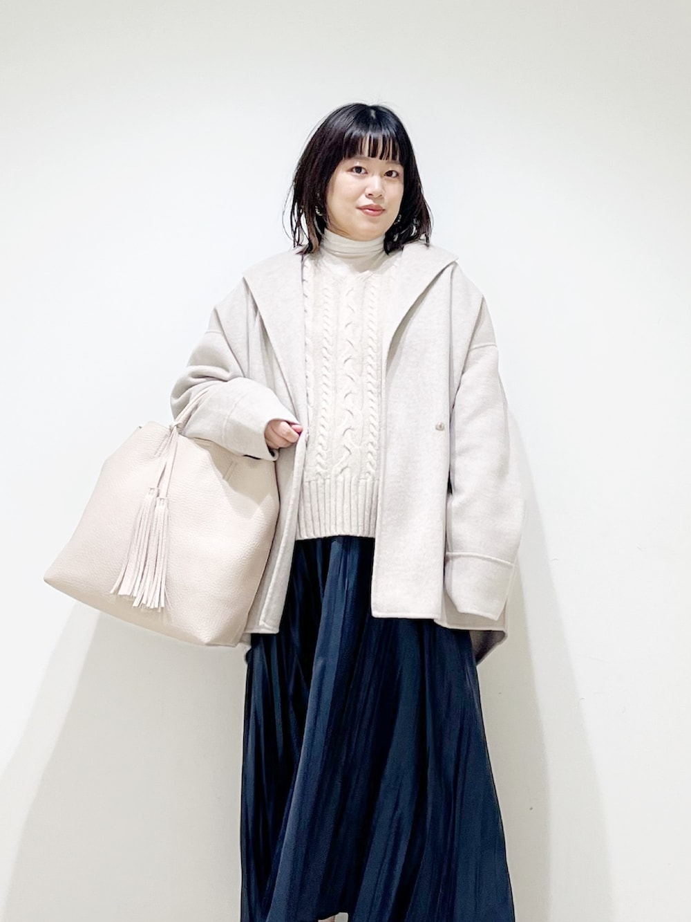 ベージュ系のその他アウター、ベージュ系のニット/セーター、ホワイト系のトートバッグを着用したレディースの秋コーディネートの3枚目の写真