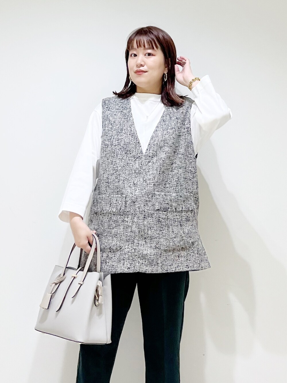 グレー系のトップス、グリーン系のパンツ、グレー系のトートバッグを着用したレディースの夏コーディネートの3枚目の写真