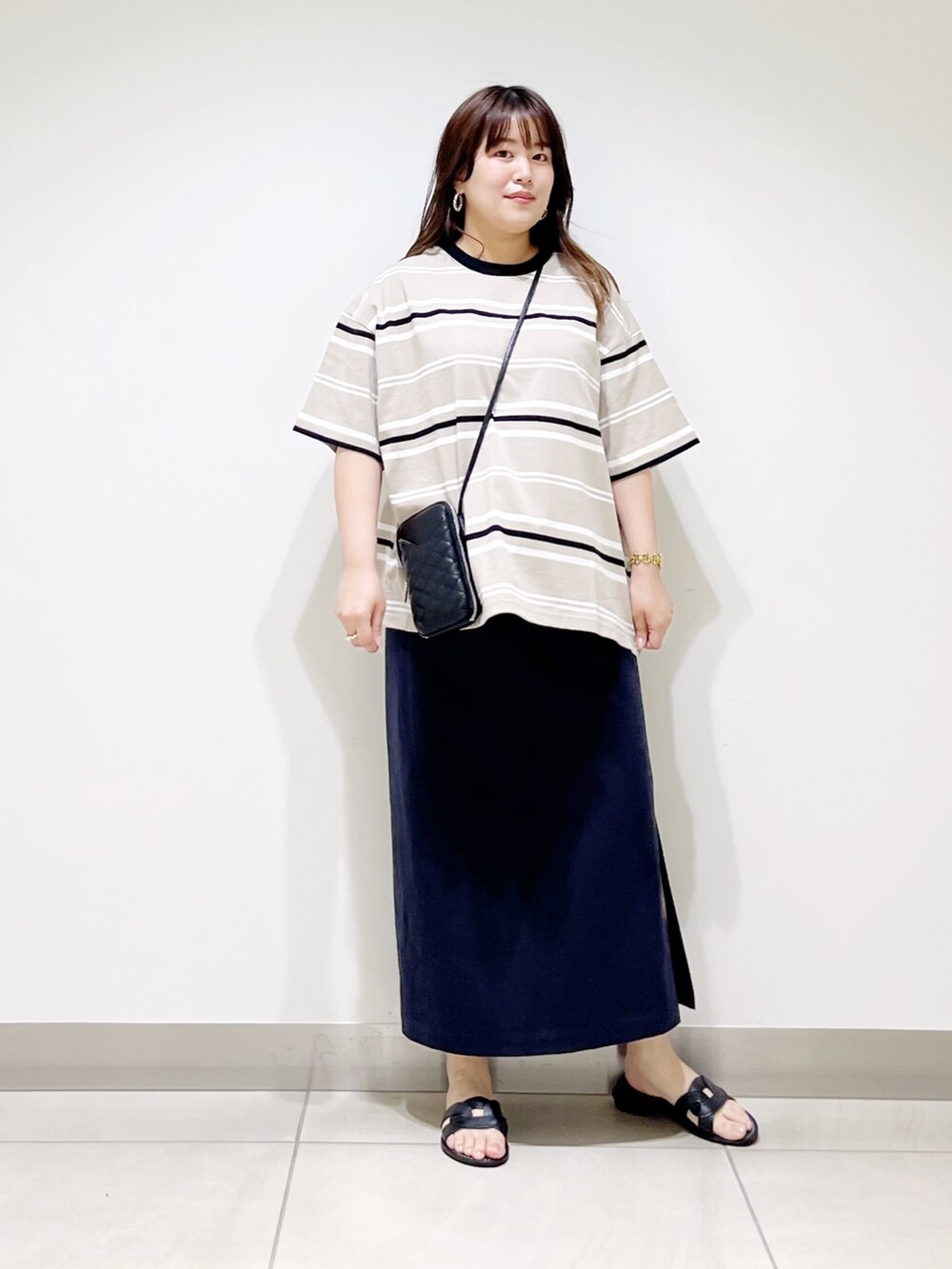 ベージュ系のTシャツ/カットソー、ブルー系のスカート、ブラック系のショルダーバッグを着用したレディースの夏コーディネートの9枚目の写真