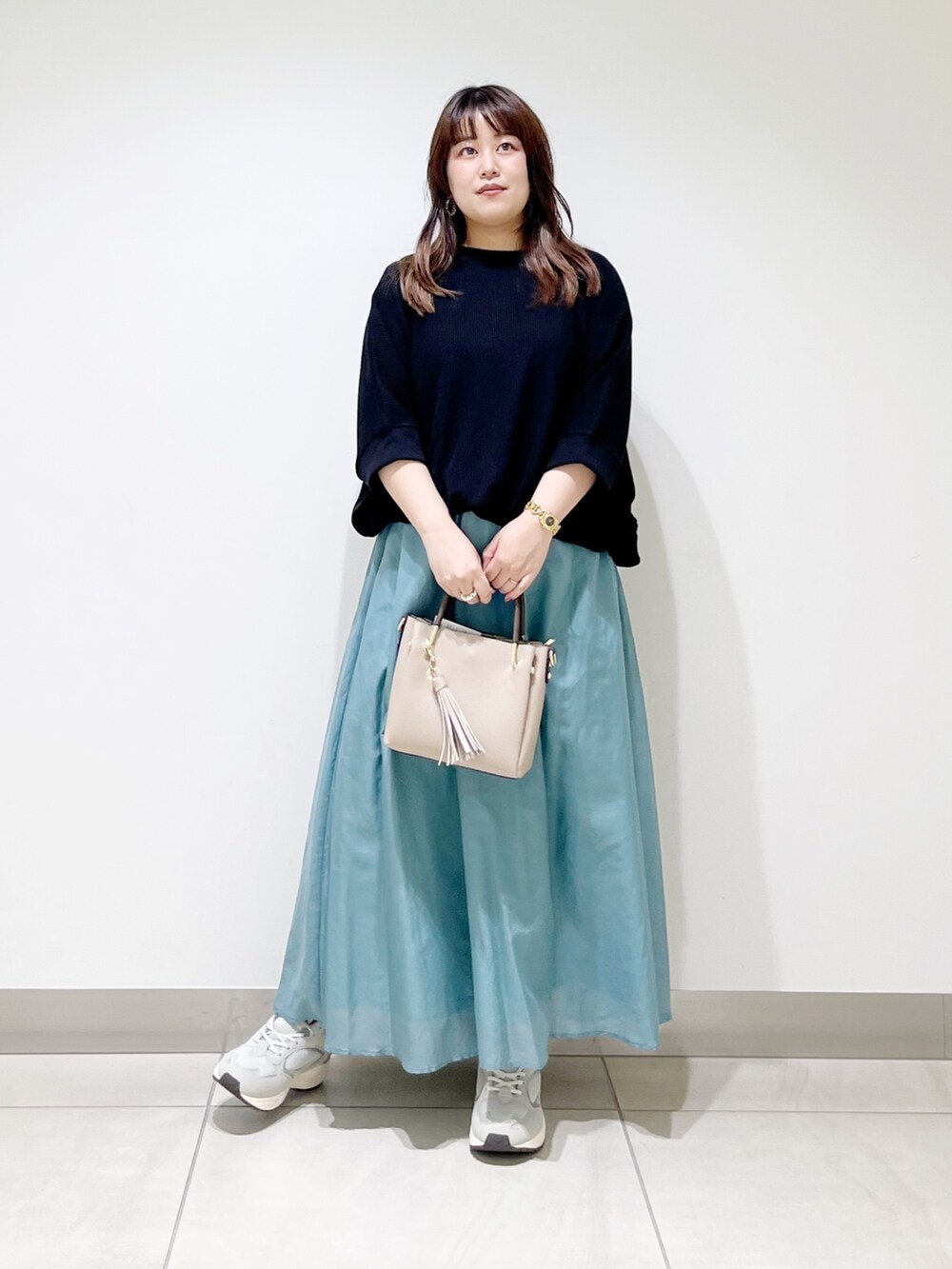 ブラック系のTシャツ/カットソー、ホワイト系のスカート、ベージュ系のトートバッグを着用したレディースの夏コーディネートの2枚目の写真